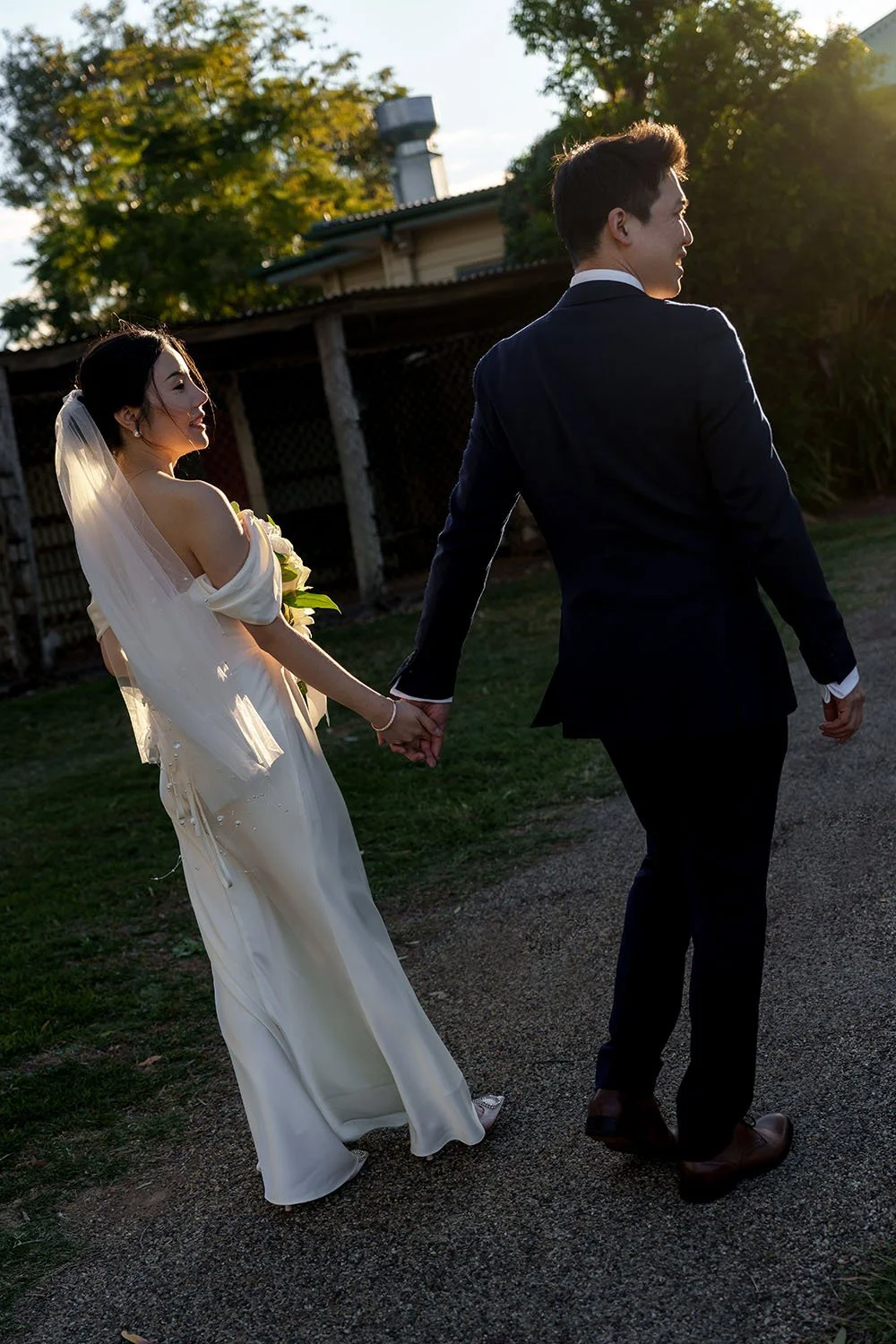 groom Eric leading bride Flora walking towards to the sun, and light become ouline for them