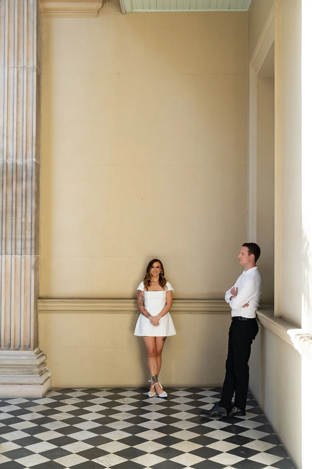 Brenna look at the camera when holding fingers and Morgan leaning on the wall crossing his arm