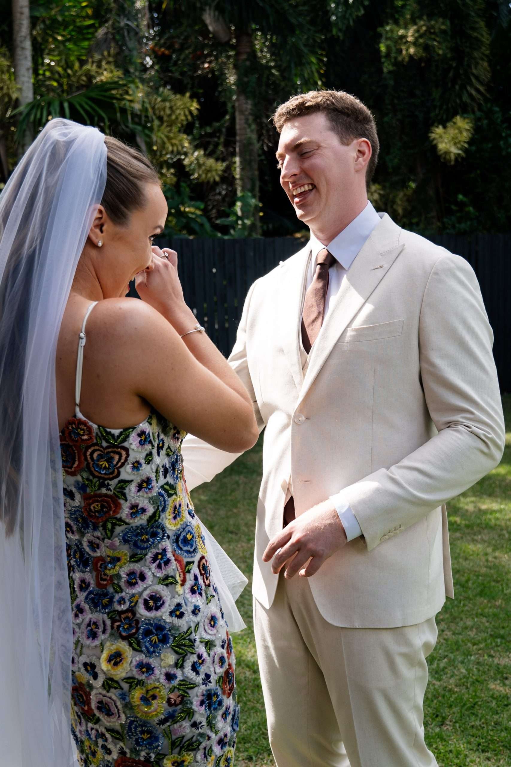 bride wipe her tears while groom groom try to holding her