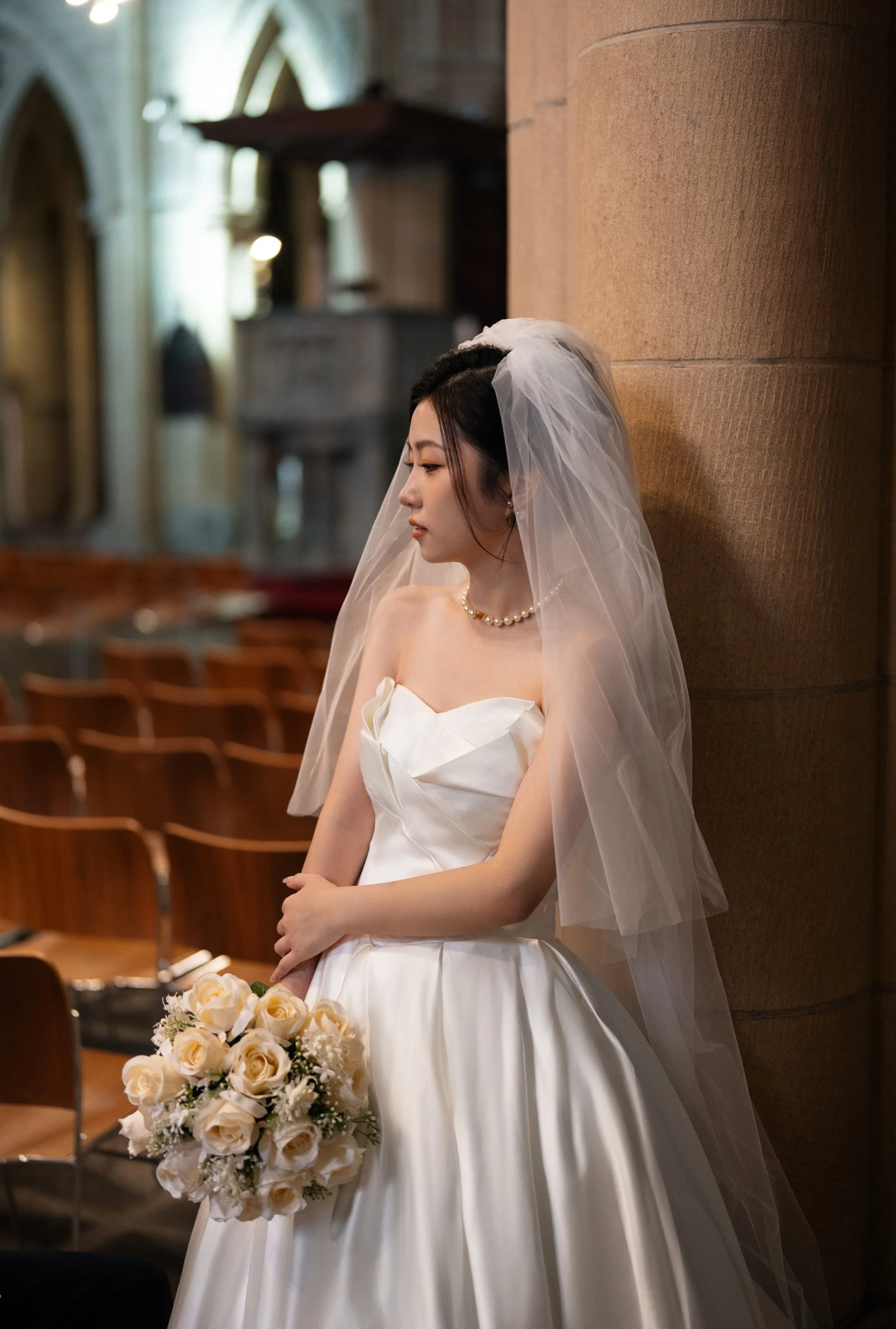 bride herself leaning on a column