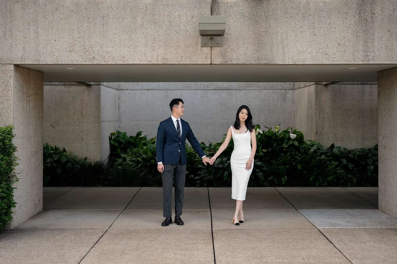Kath and Dave holding hands, with Kath looking at Brisbane wedding photographer Whistler in the Gallery of Art, capturing a candid and intimate moment surrounded by the artistic backdrop