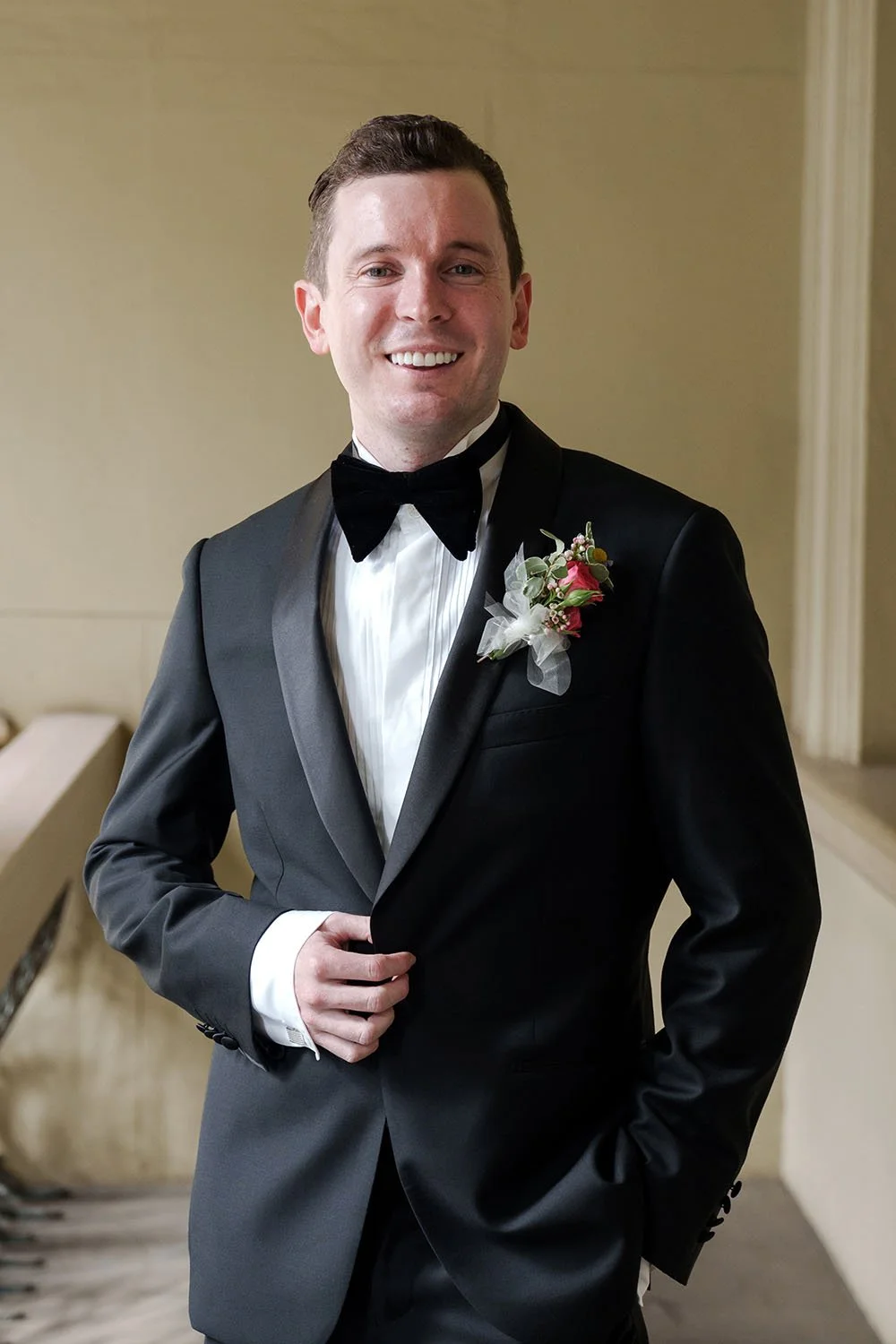 groom Cliffe hand touching his jacket button and look the Brisbane wedding photographer Whistler