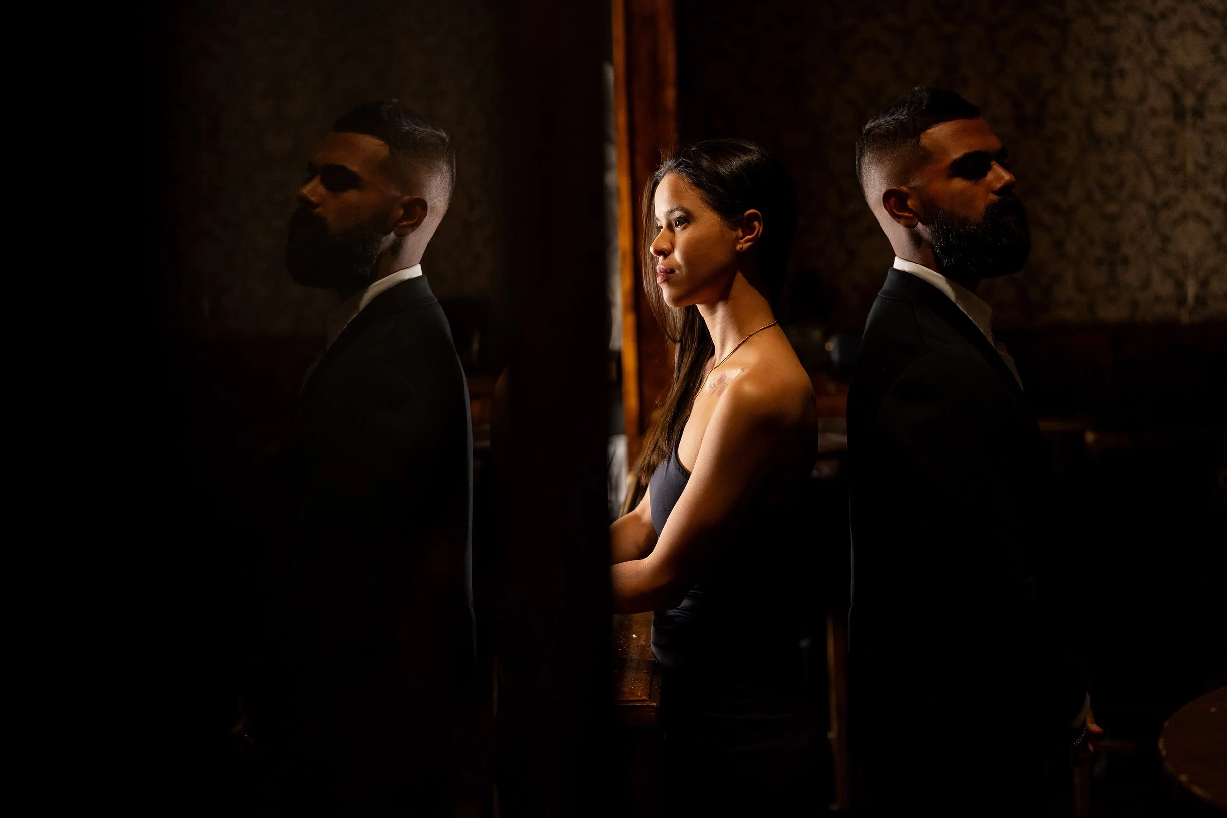 Jasmin and Jay back to back standing, mirror reflection shows Jay, and they both look forward