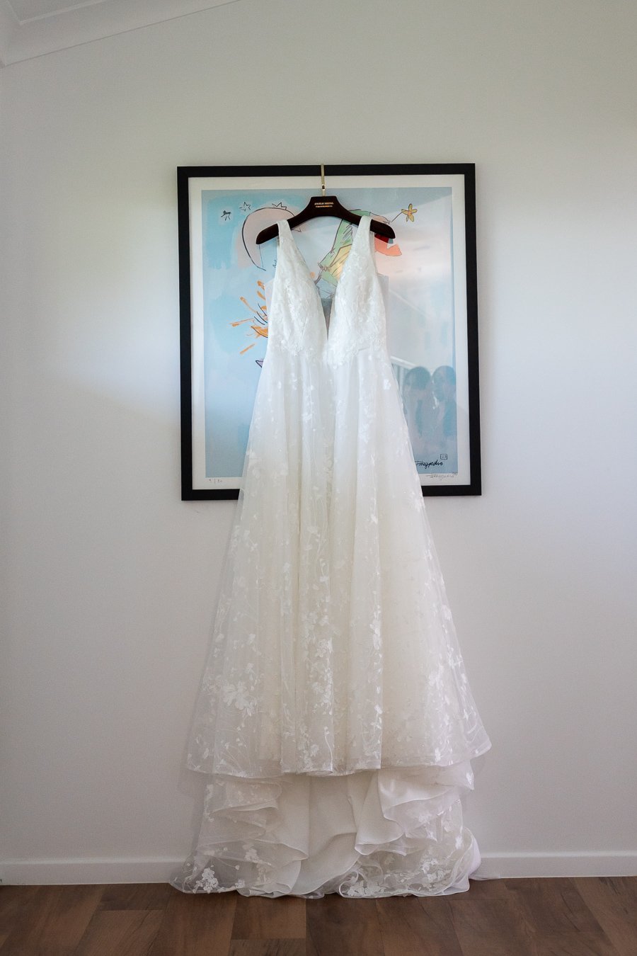 Chiarra's wedding dress hanging on the a painting