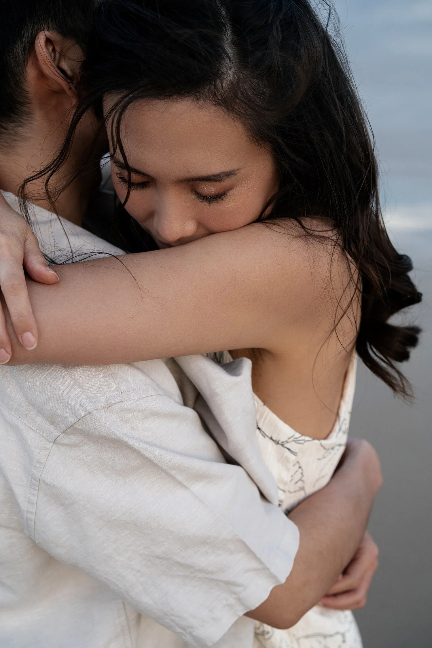 Krystel hugging Paul in Currumbin Alley, surrounded by the natural beauty of the area. The moment captures their closeness and affection, with the scenic backdrop enhancing the intimacy and warmth of their embrace
