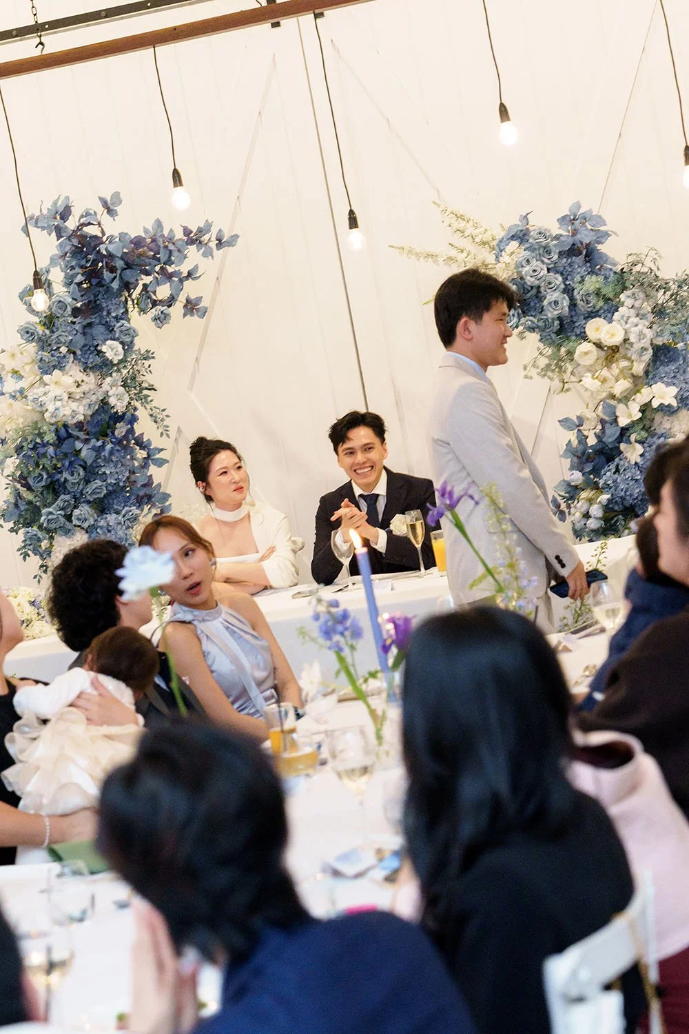Lisa's little brother walking pass the bridal table to make a speech and Michael Lisa smell