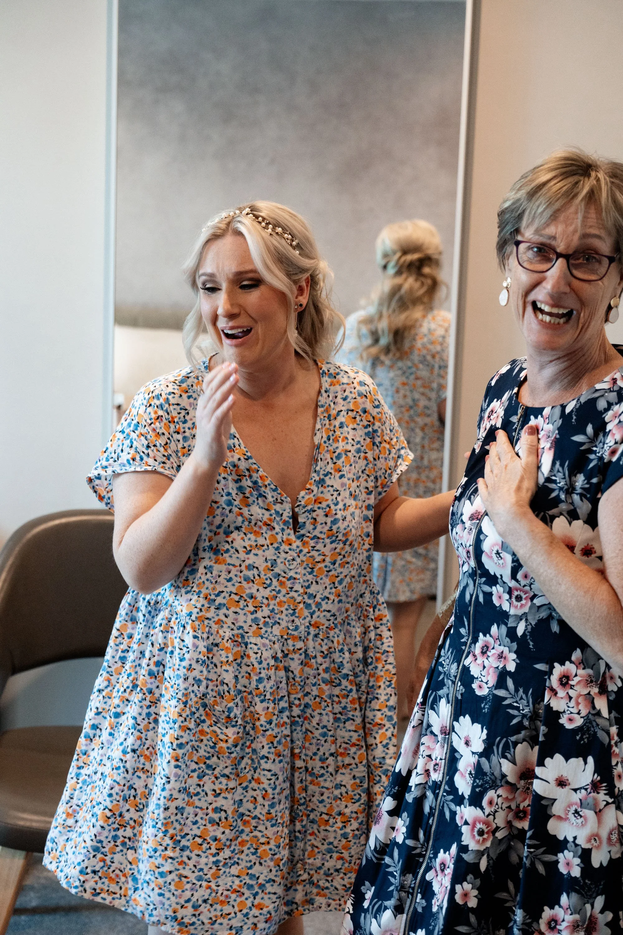 Bride Kyra and her mother-in-law sharing an emotional moment, both in tears, as they embrace the significance of the wedding day