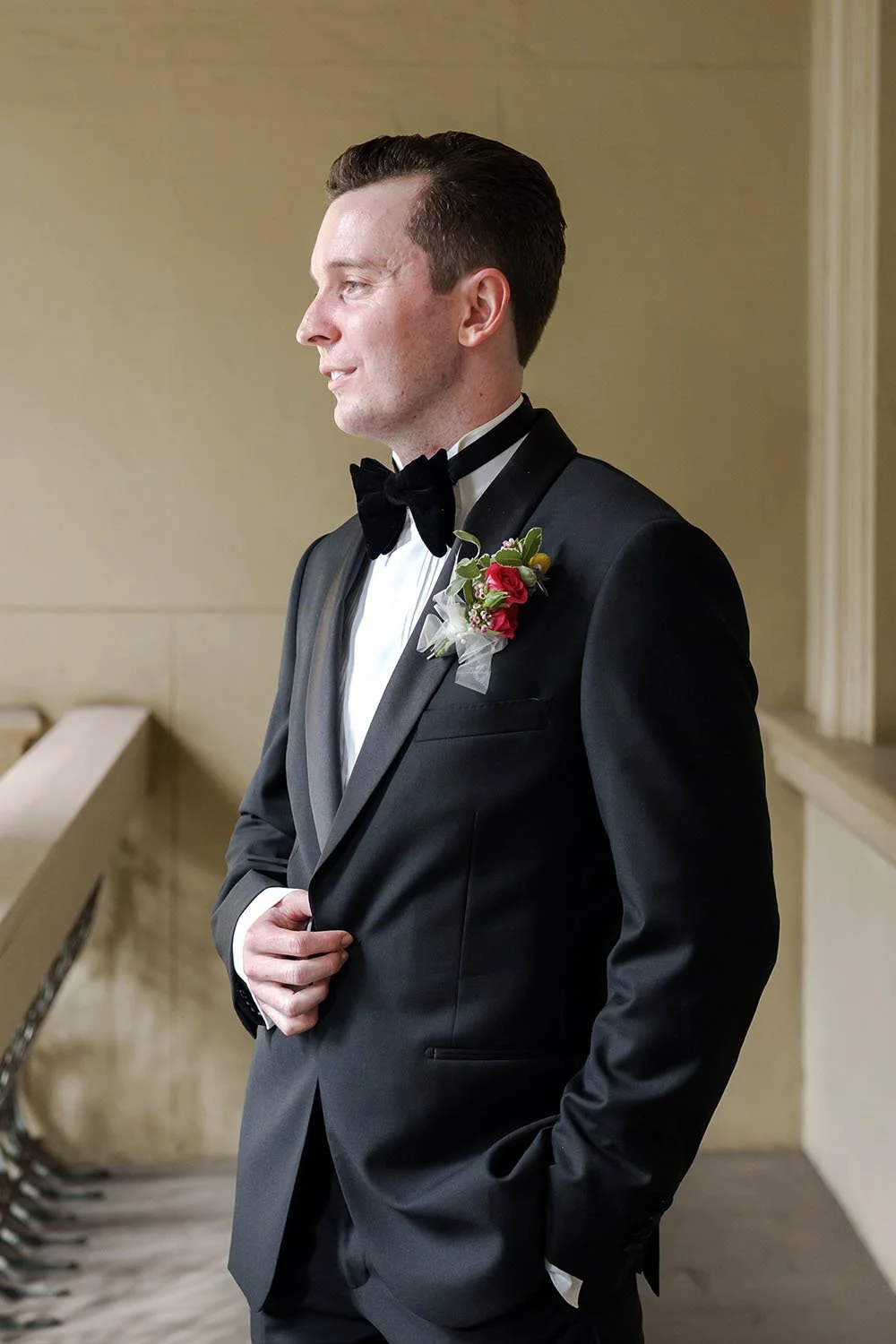 groom Cliffe hand touching his jacket button and look away