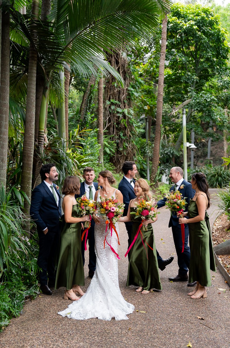 hand shaking groom with his groomsman, and brides mate talking to best man