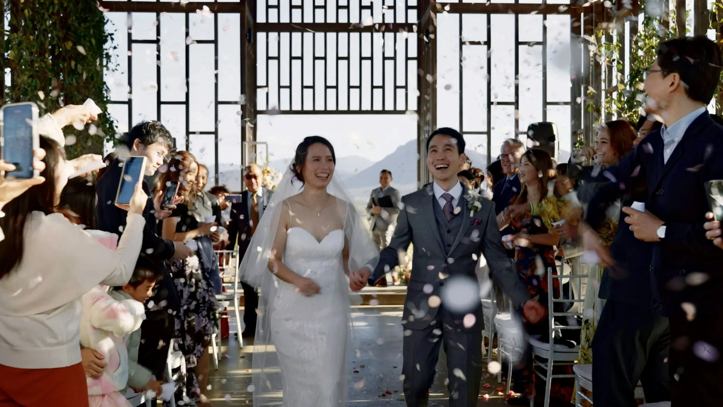 Krystel and Paul walking down the aisle and all their guest throw biodegradable petals to them