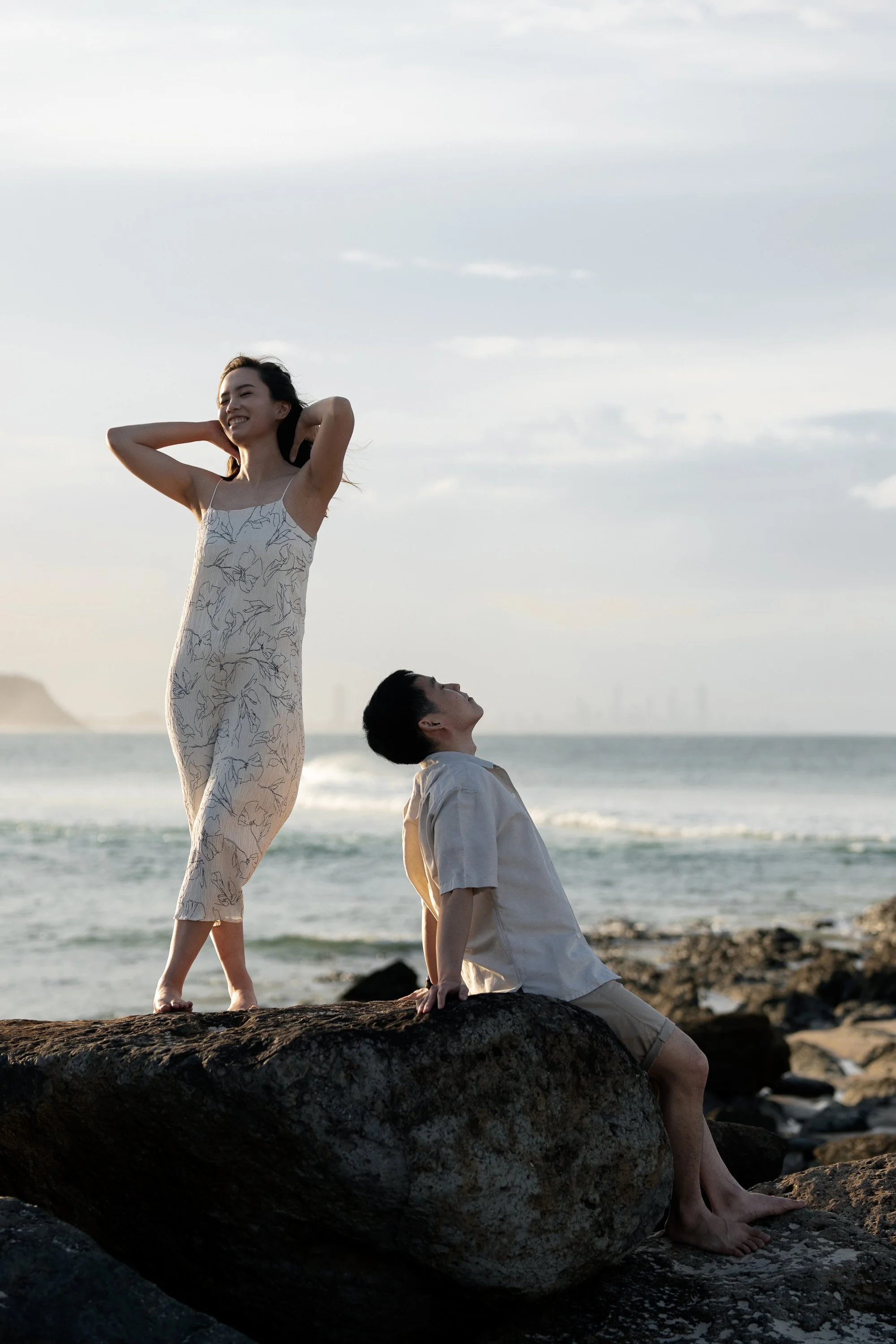 Krystel pull back her hair face to the sunset and Paul setting next to her with head up in Currumbin Alley