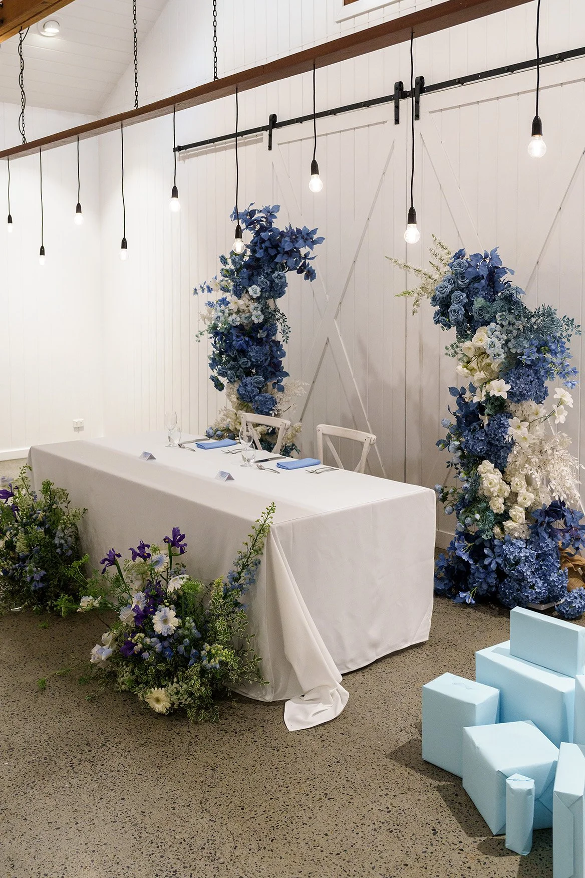 bridal table set up in summergrove estate, blue and purple flower behind chairs