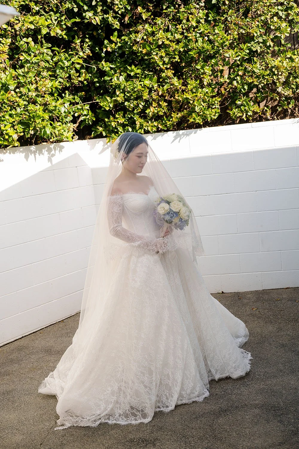 a veil cover over Lisa's head, and she holding her flower too