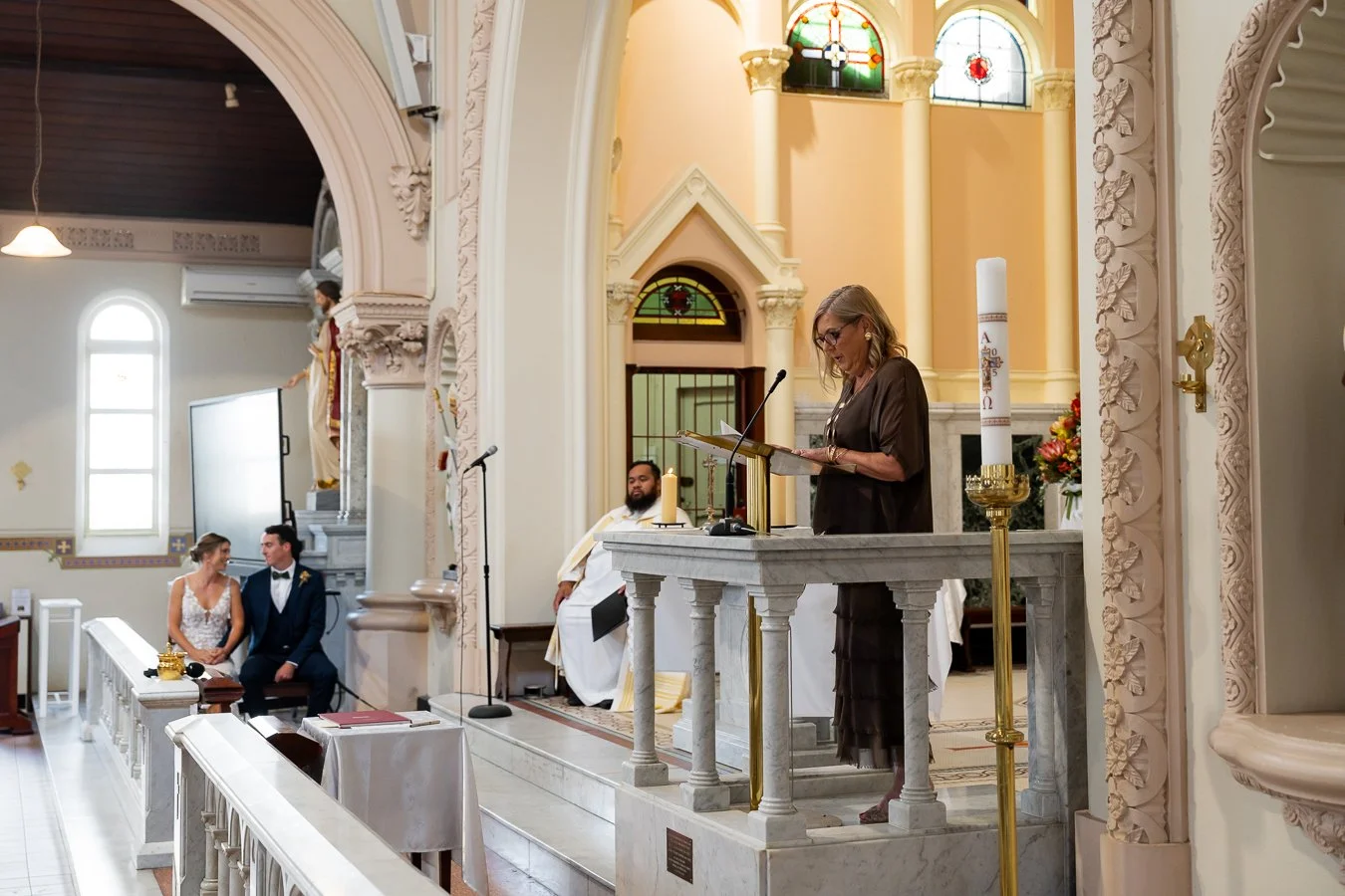 The bride’s mother was doing a reading at the altar, while the bride and groom sat hand in hand at a distance
