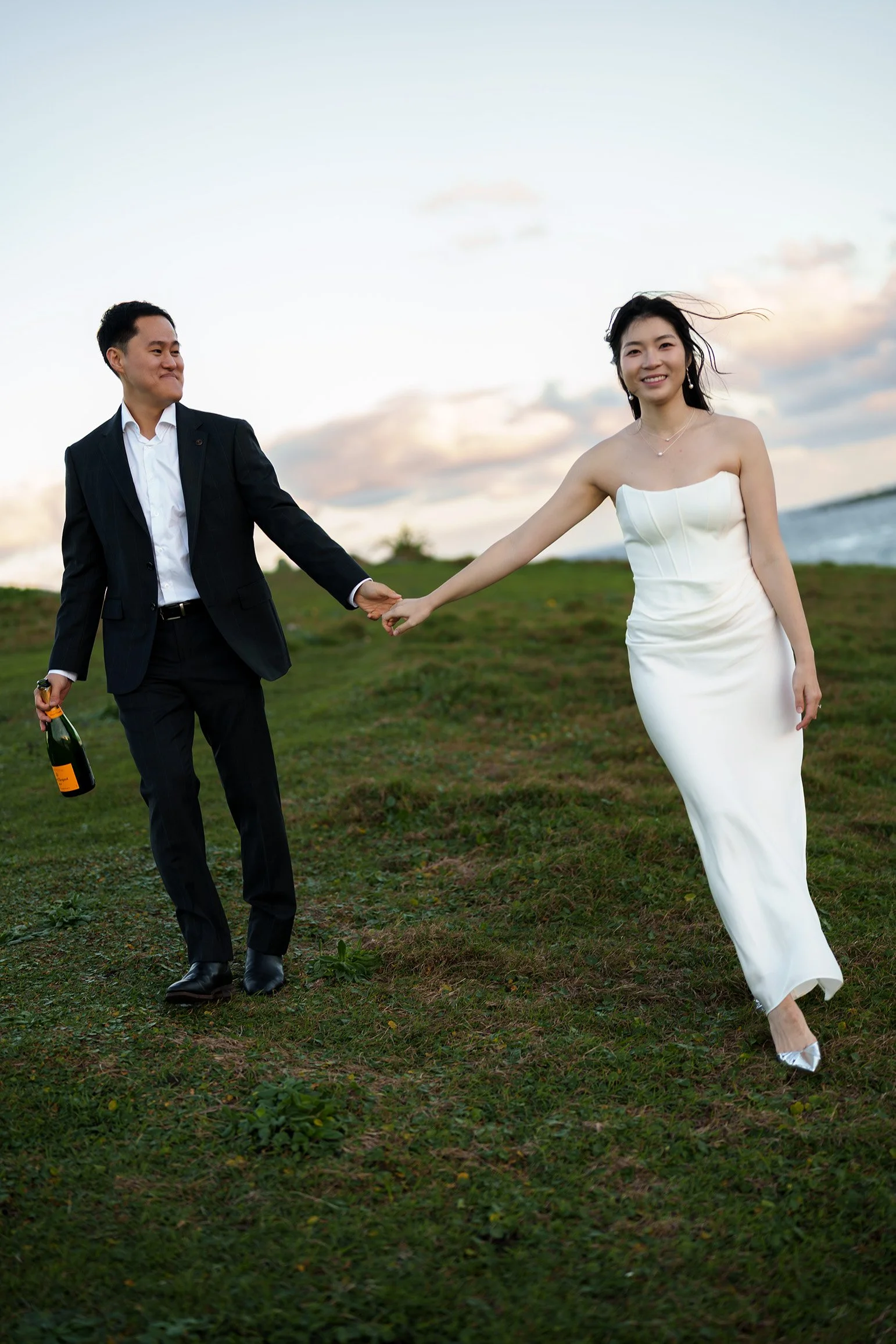 Silva one hand holding a bottle of champagne and the other hand holding Margaret while she look a the camera