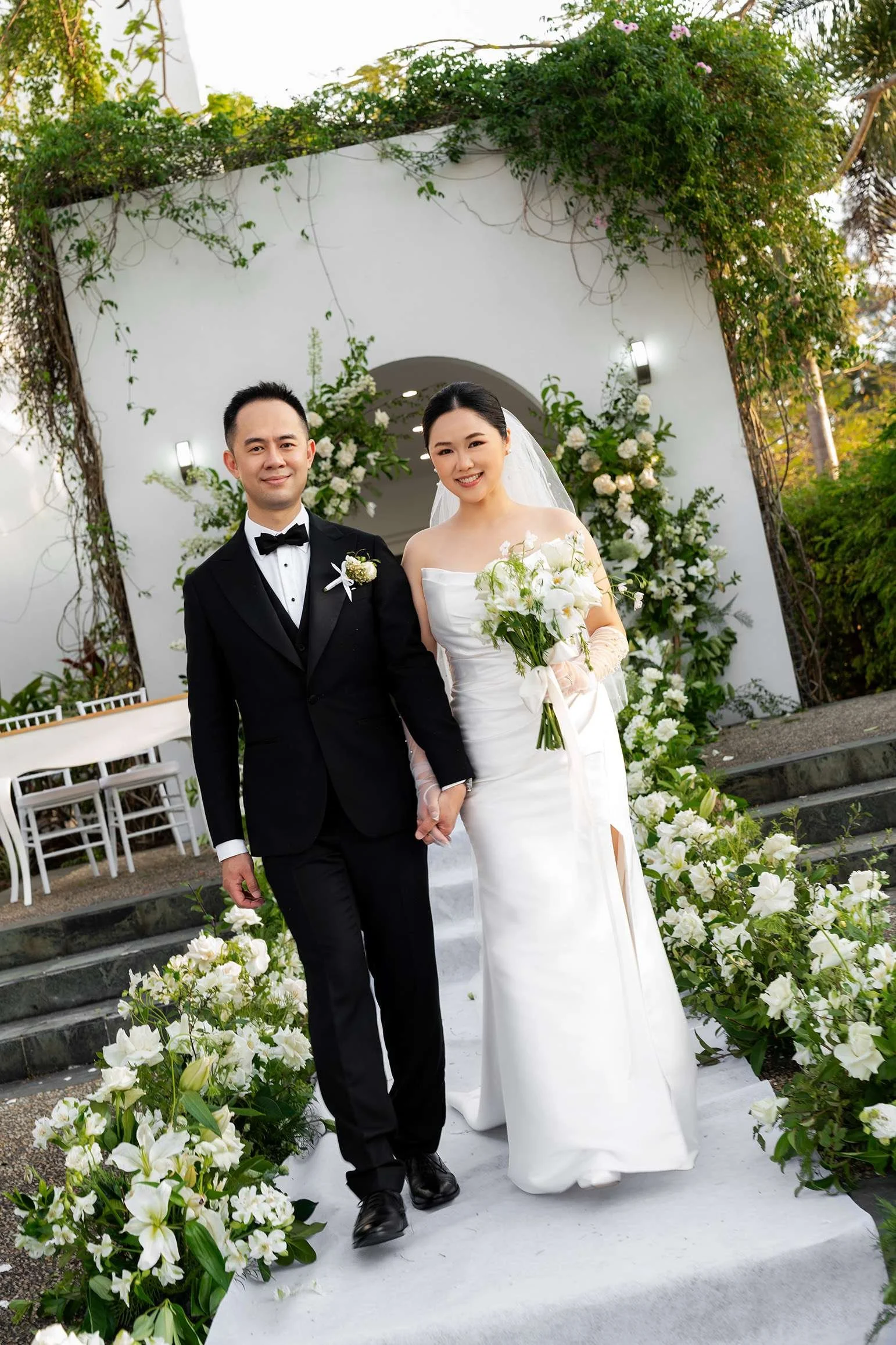 Alex and Wendy hands holding both look at the Brisbane wedding photographer Whistler Li in their ceremony spot