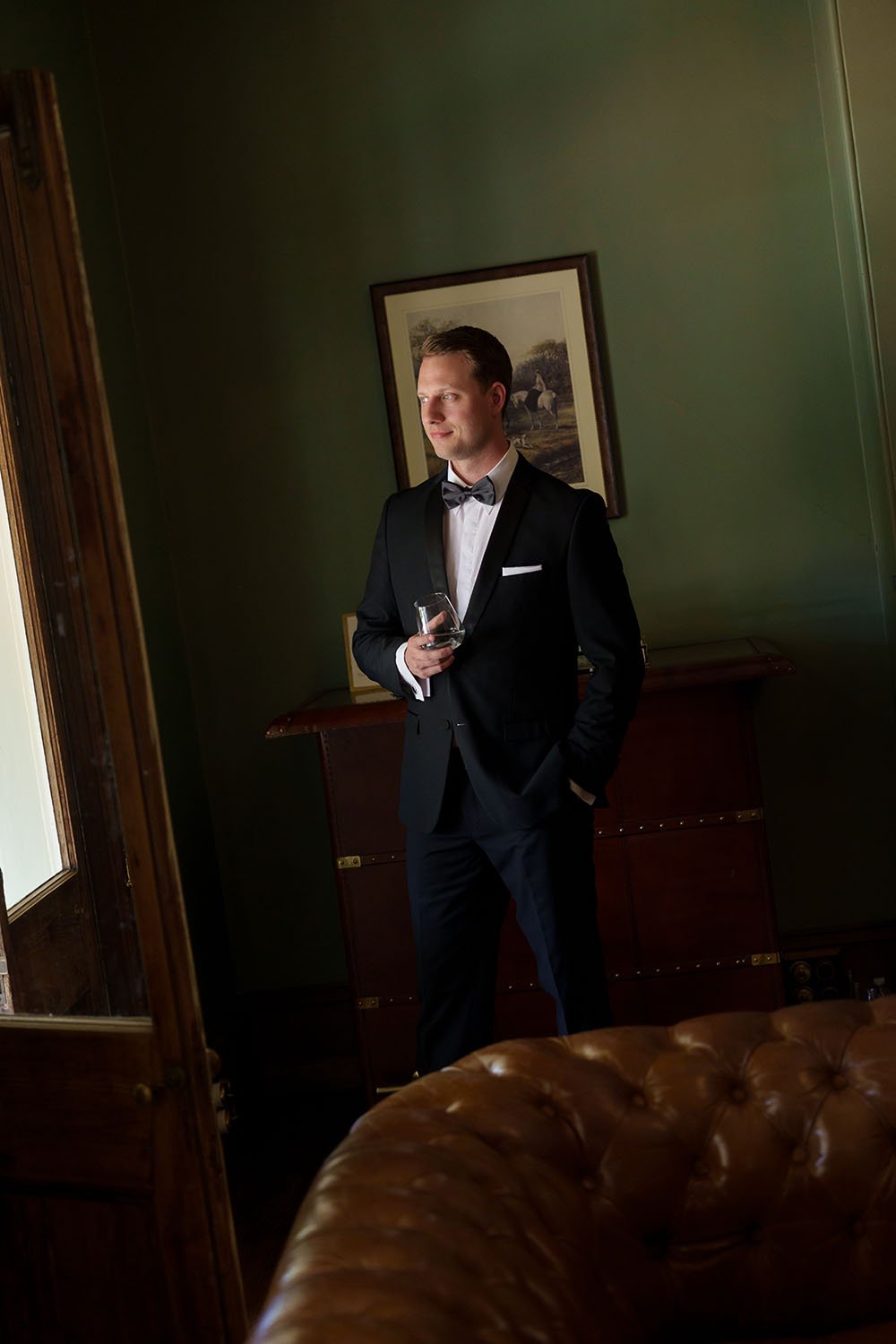 Morgan stand next to a door while holding a drink