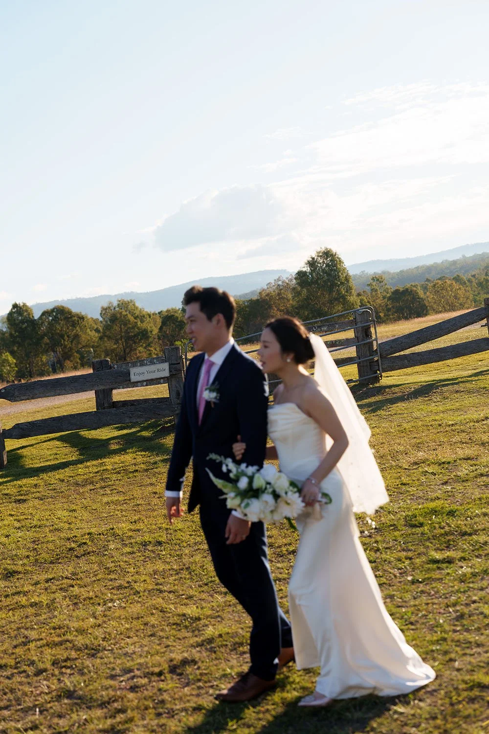 Eric and flora hold hands, swing your arms, and walk straight with backlight, enjoy your ride letter at the background