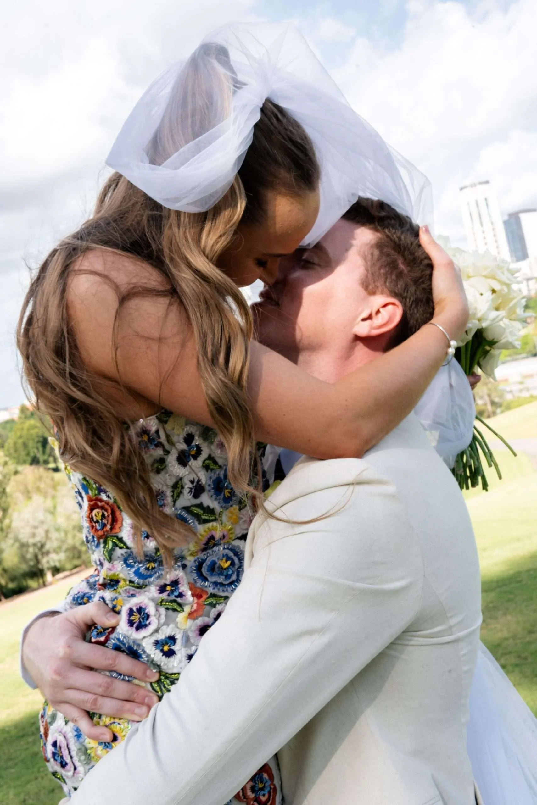 Groom lifting the bride as they lean in for a kiss.