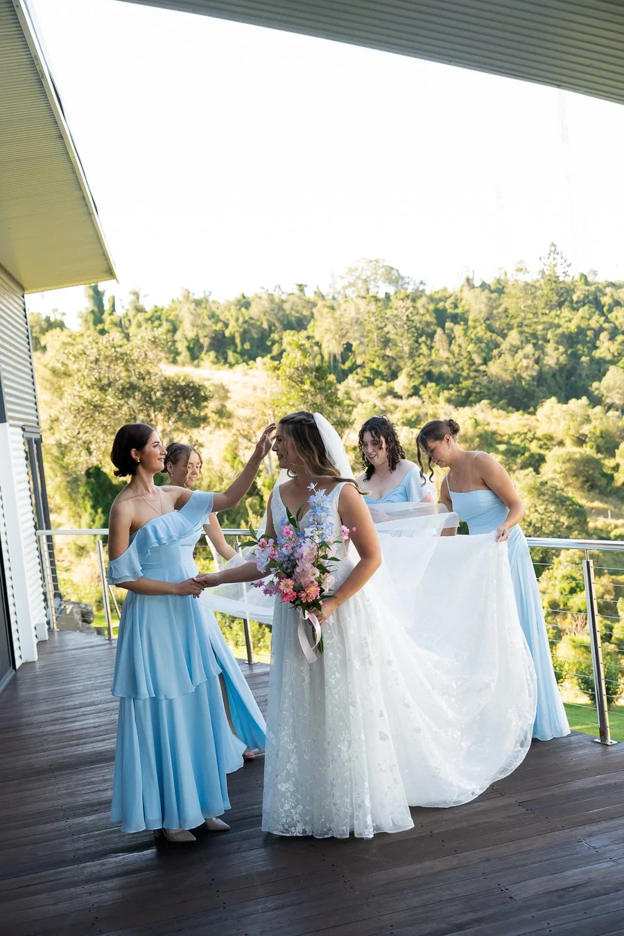 one of the bride mates adjusting bride Chiarra's hir
