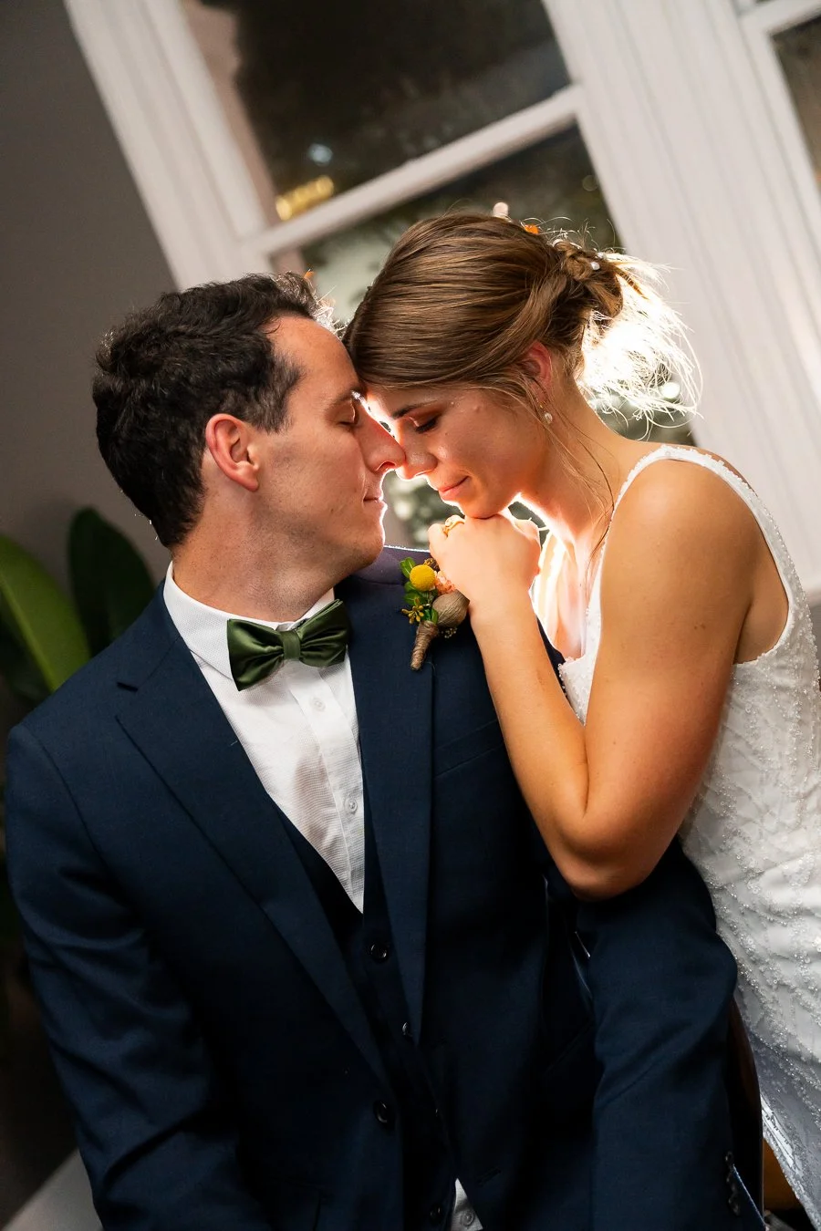 bride Sonya two hands on groom Giordan's shoulder and they both close eyes with back light fire behind them