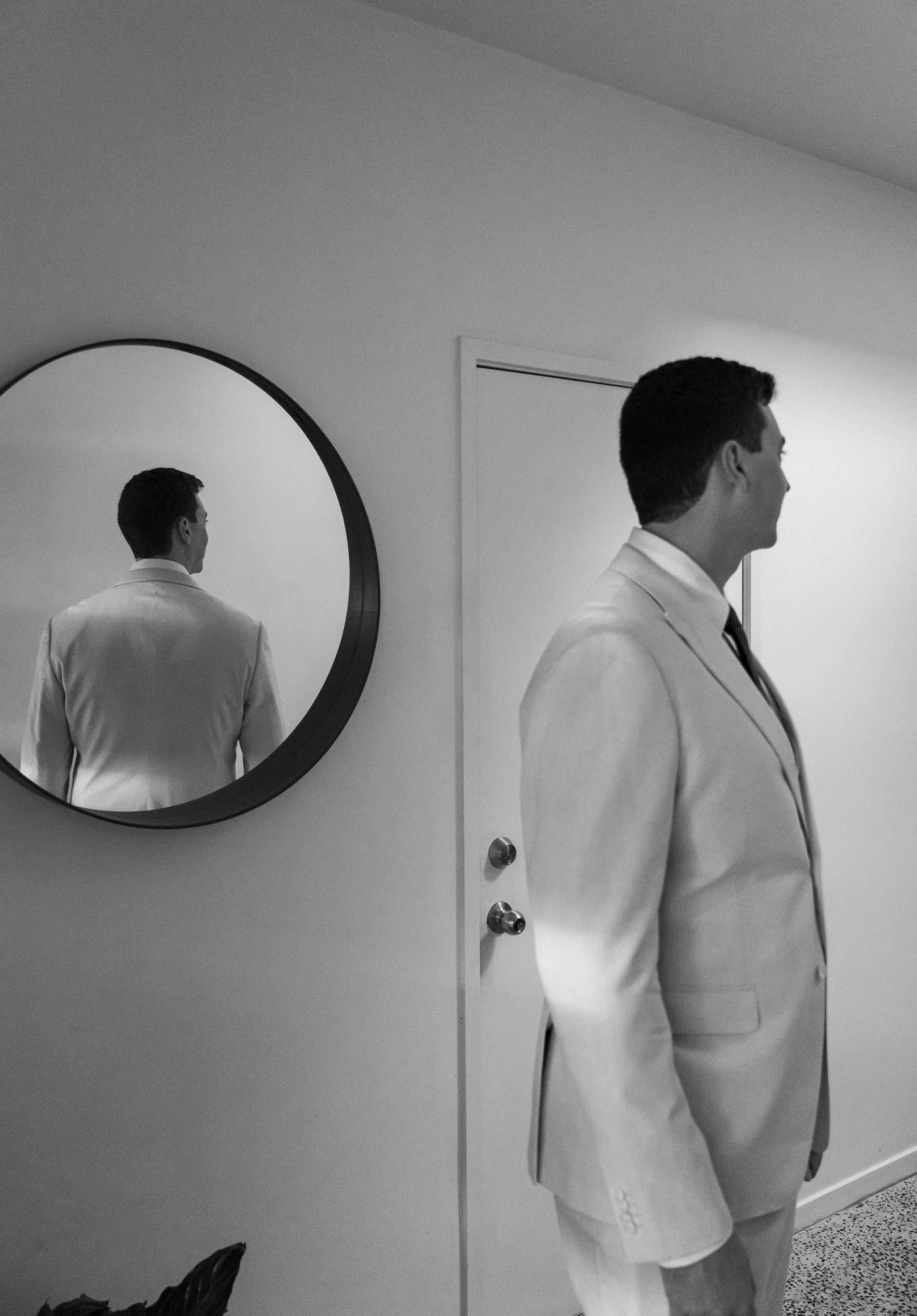 Mirror reflection showing the groom’s back while he look away