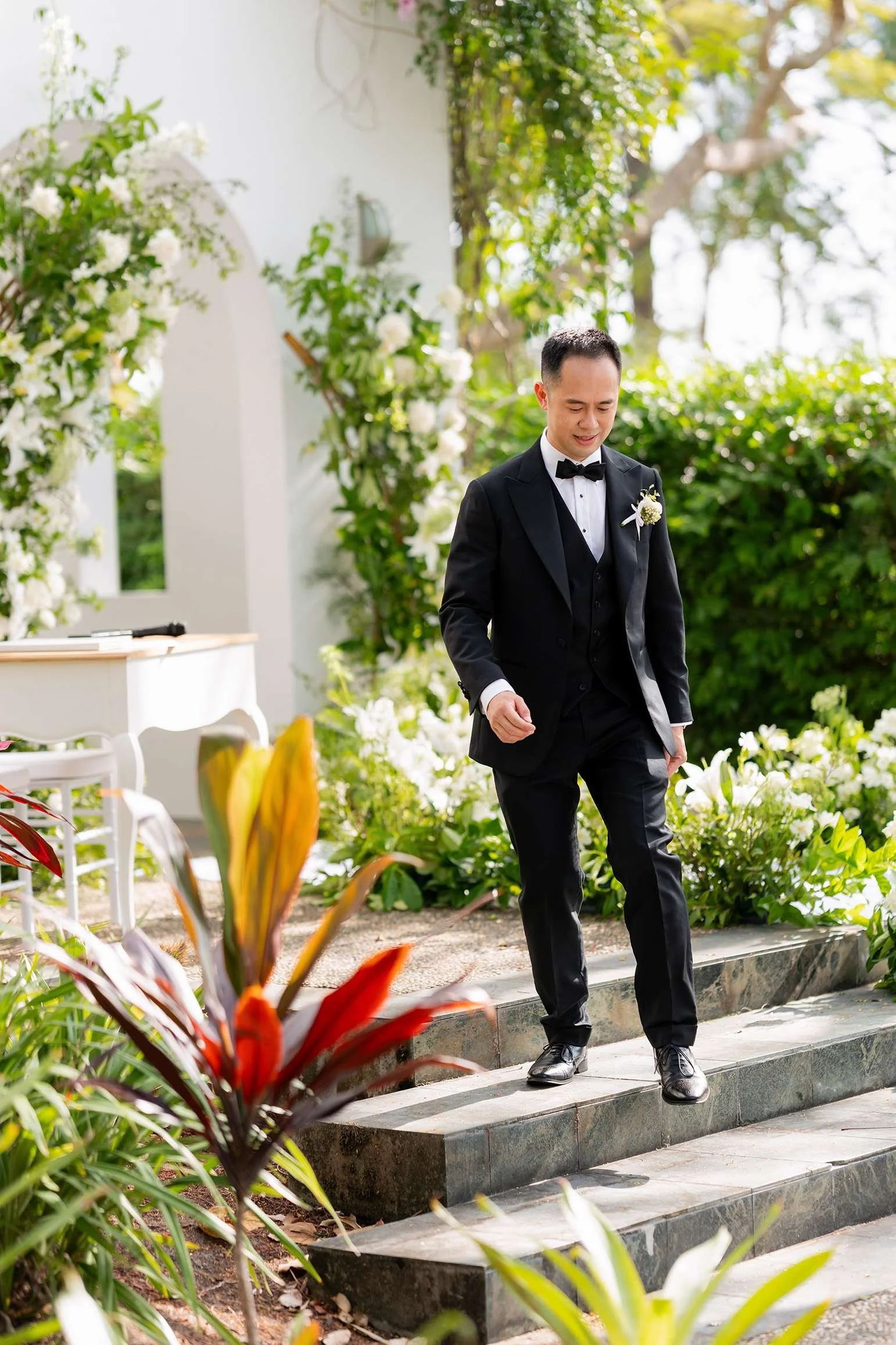 groom Alex walking down the stairs