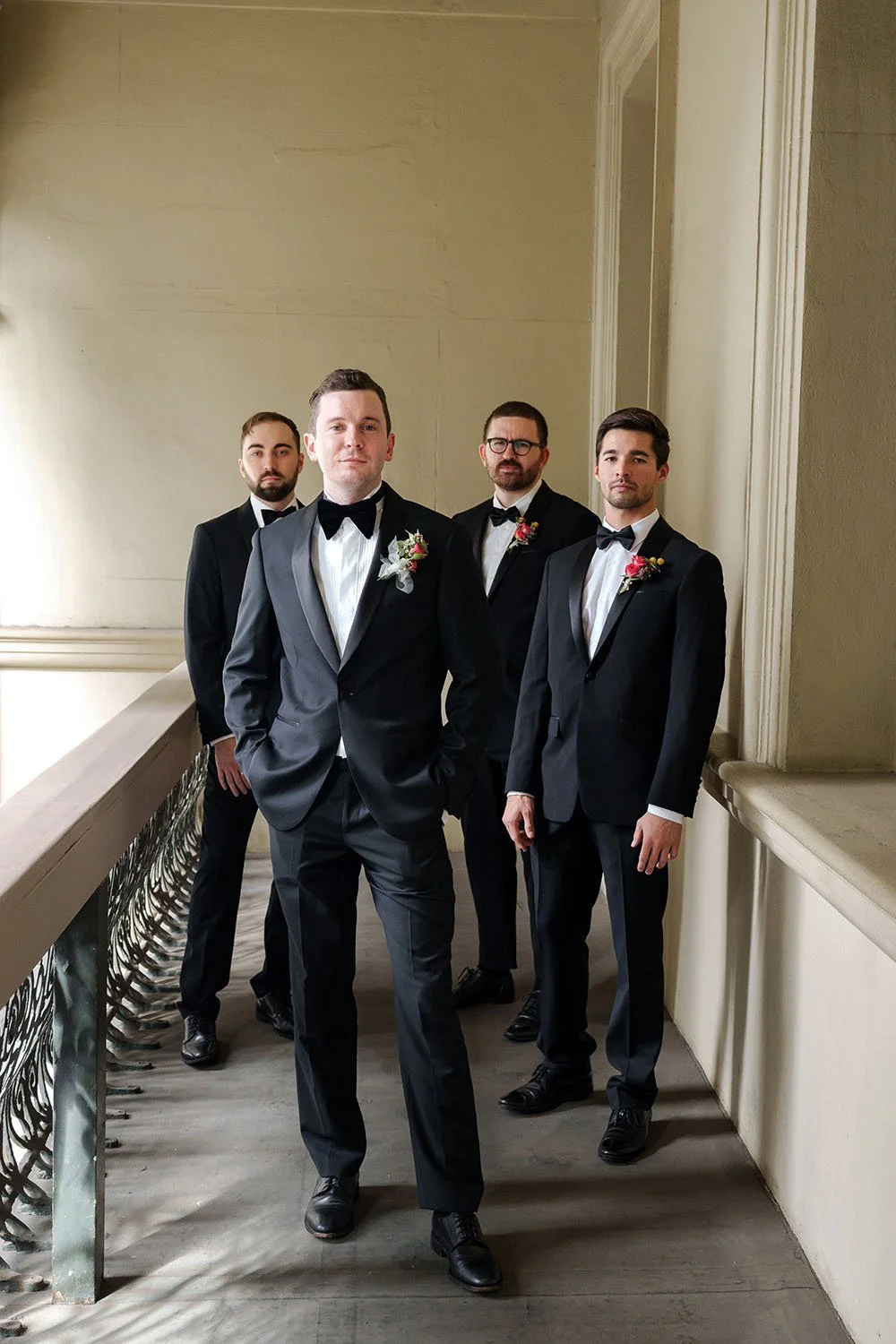 groom Cliffe stand in front of his groomsmen and they both look forwards
