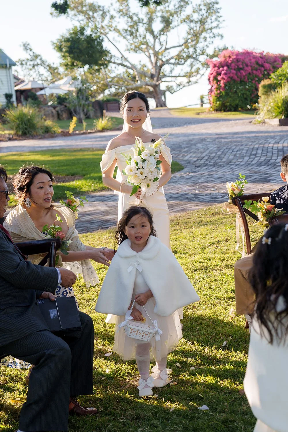 Flora look at Eric with holding flower, one flower girl infront of her