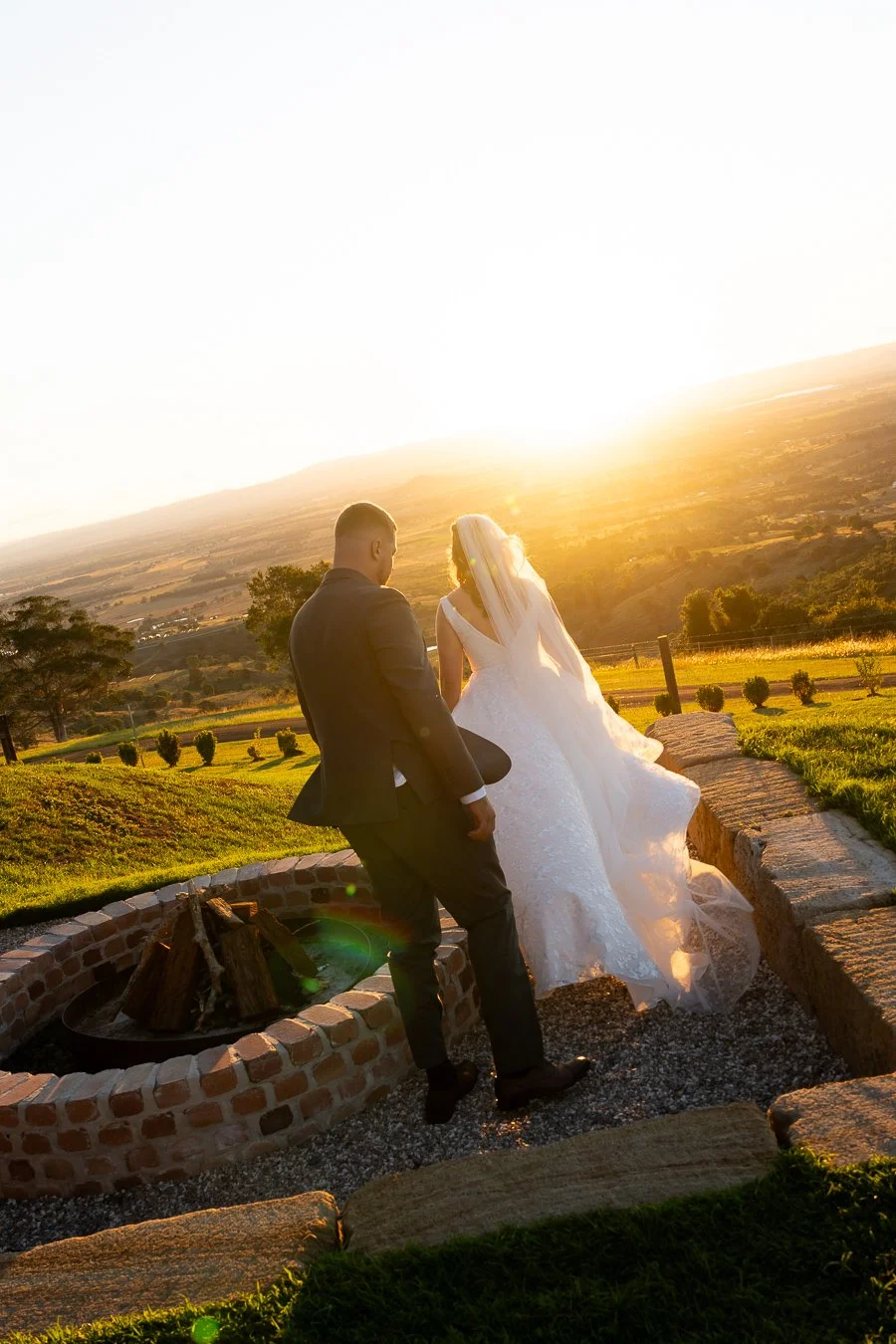 bride Chiarra and groom Ben walking away from the camera towards to the sunset in Western Ridge
