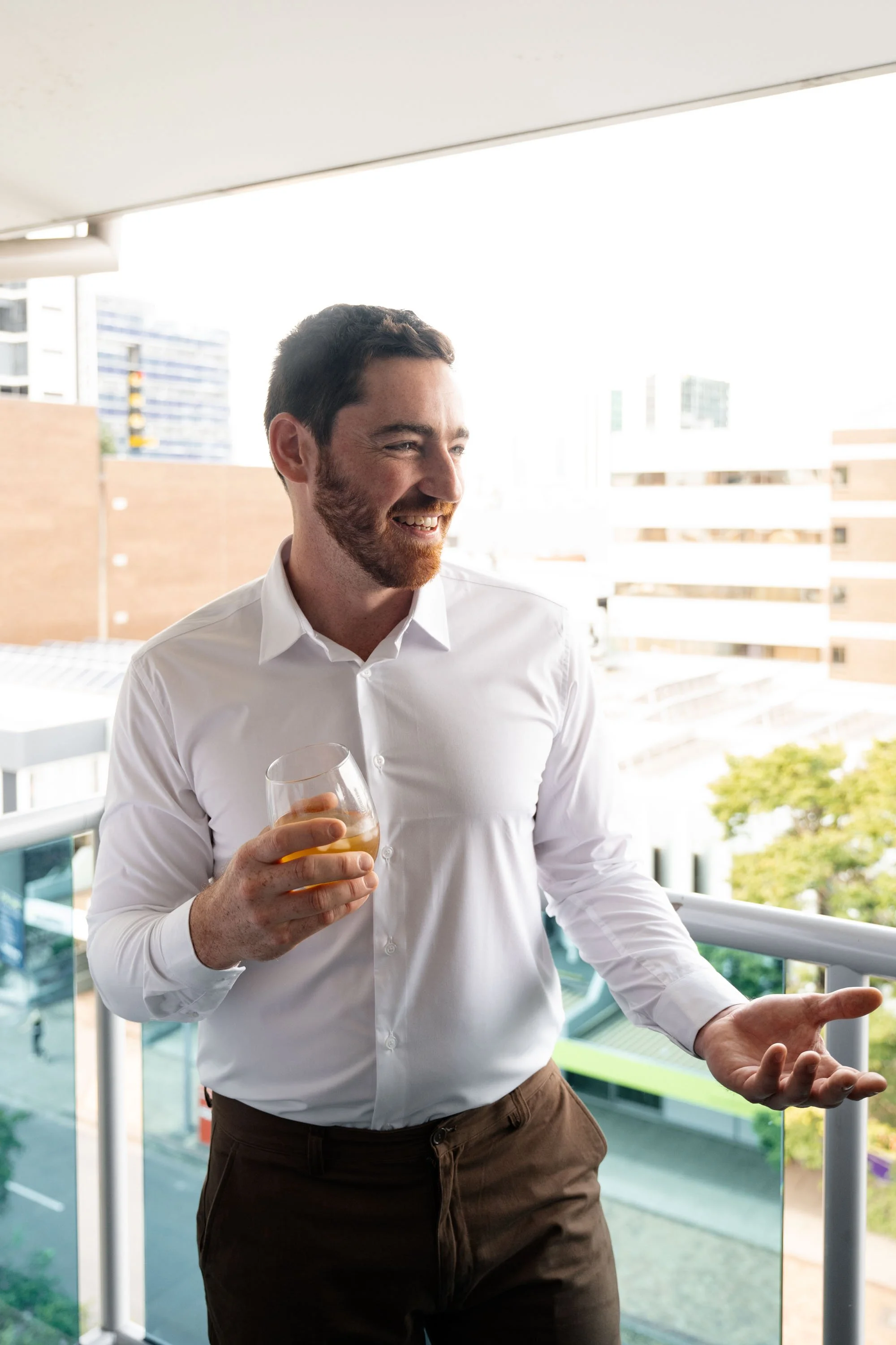groom Thomas holding a glass of whiskey talk to the person next to him