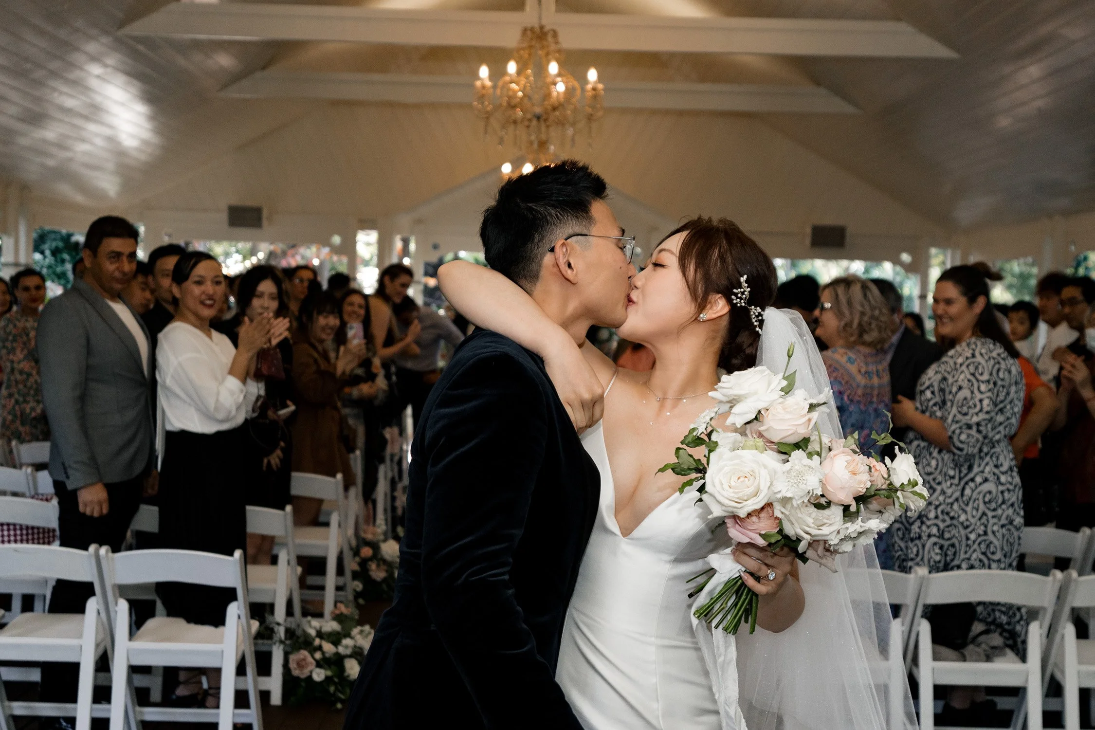 bride Vicky holding groom Brus' neck and kiss him after wedding ceremony un a gazebo in gabbinbar homestead