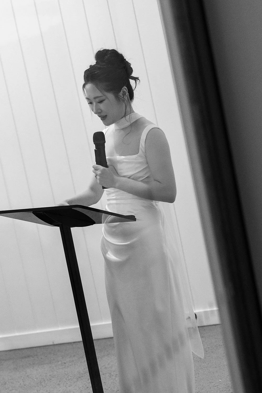 Lisa holding a mic speak on next to the lectern