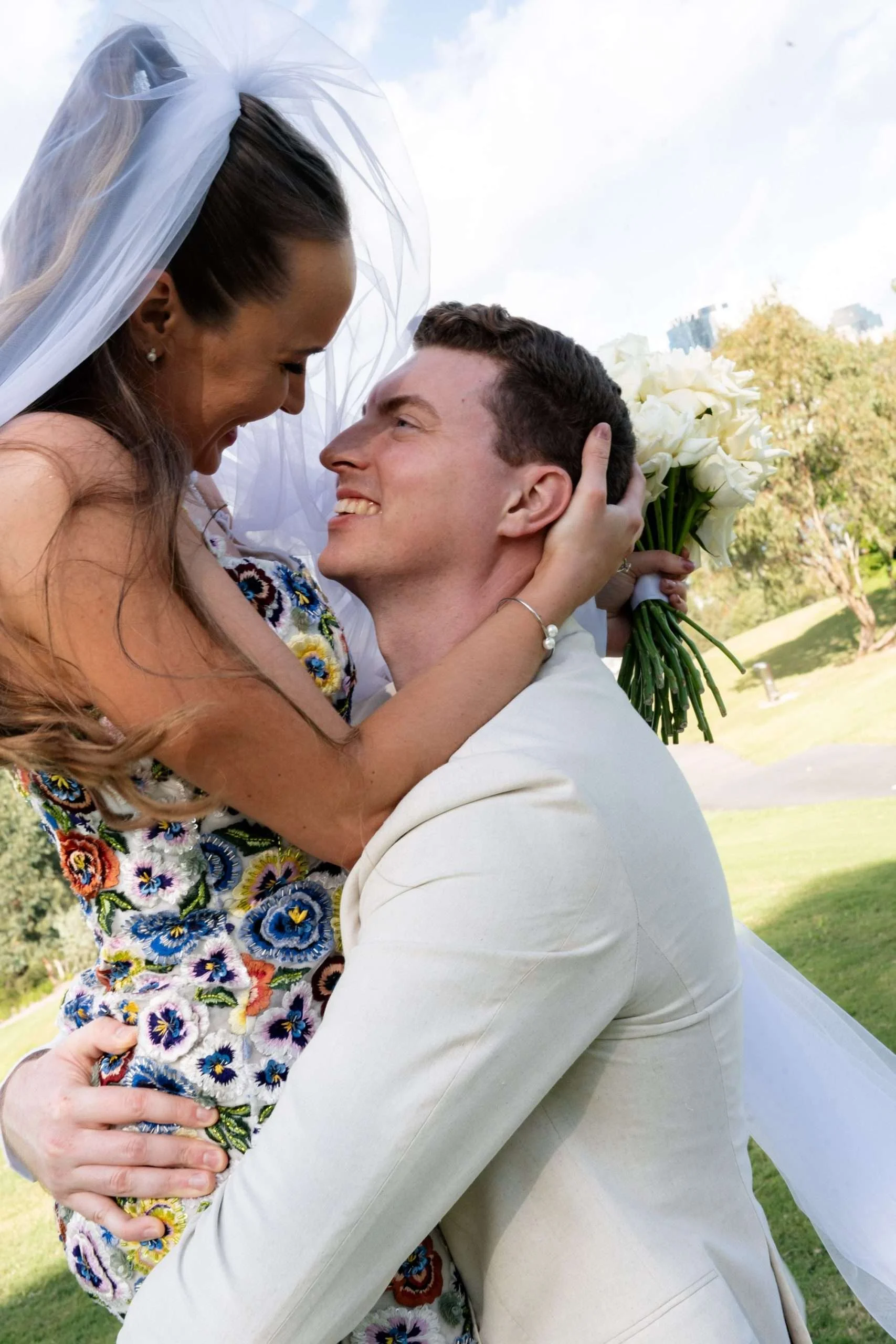 Groom lifting the bride as they laughing at each other