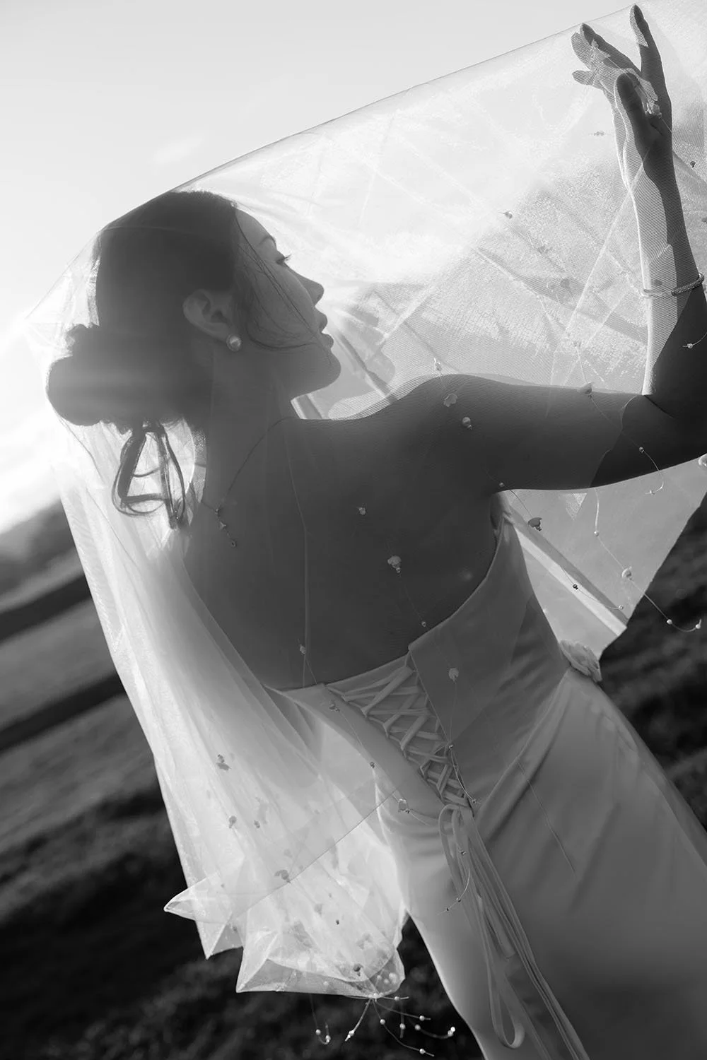 veil covering Flora's head, and her hands support the veil inside, and look it