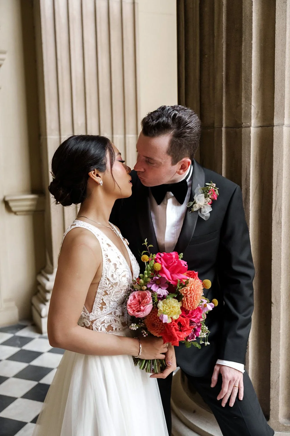 bride Nori and groom Cliffe try to kissing each other in front of the custums house