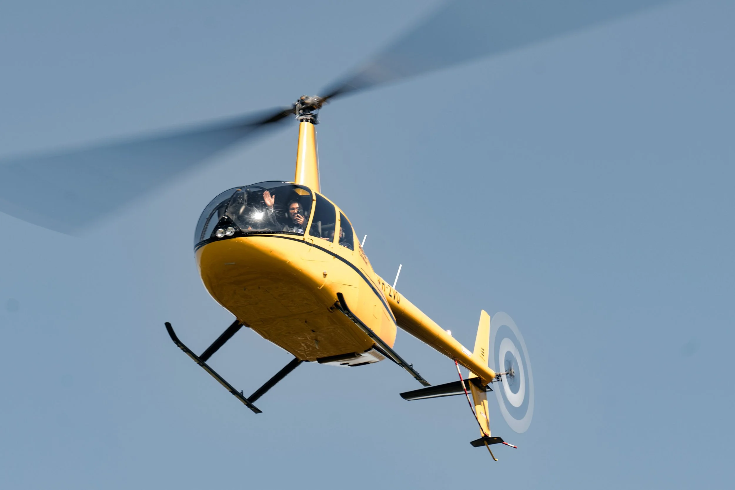 yellow helicopter in air, and groom Brus waving hand to the Brisbane wedding photographer