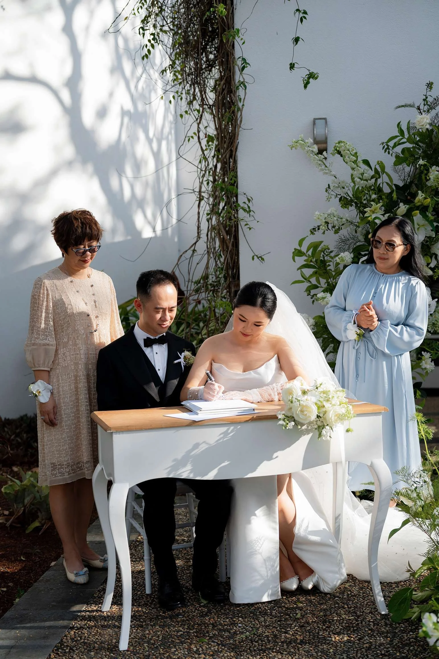 bride Wendy signing the marriage cetificate, two mum stand behind them