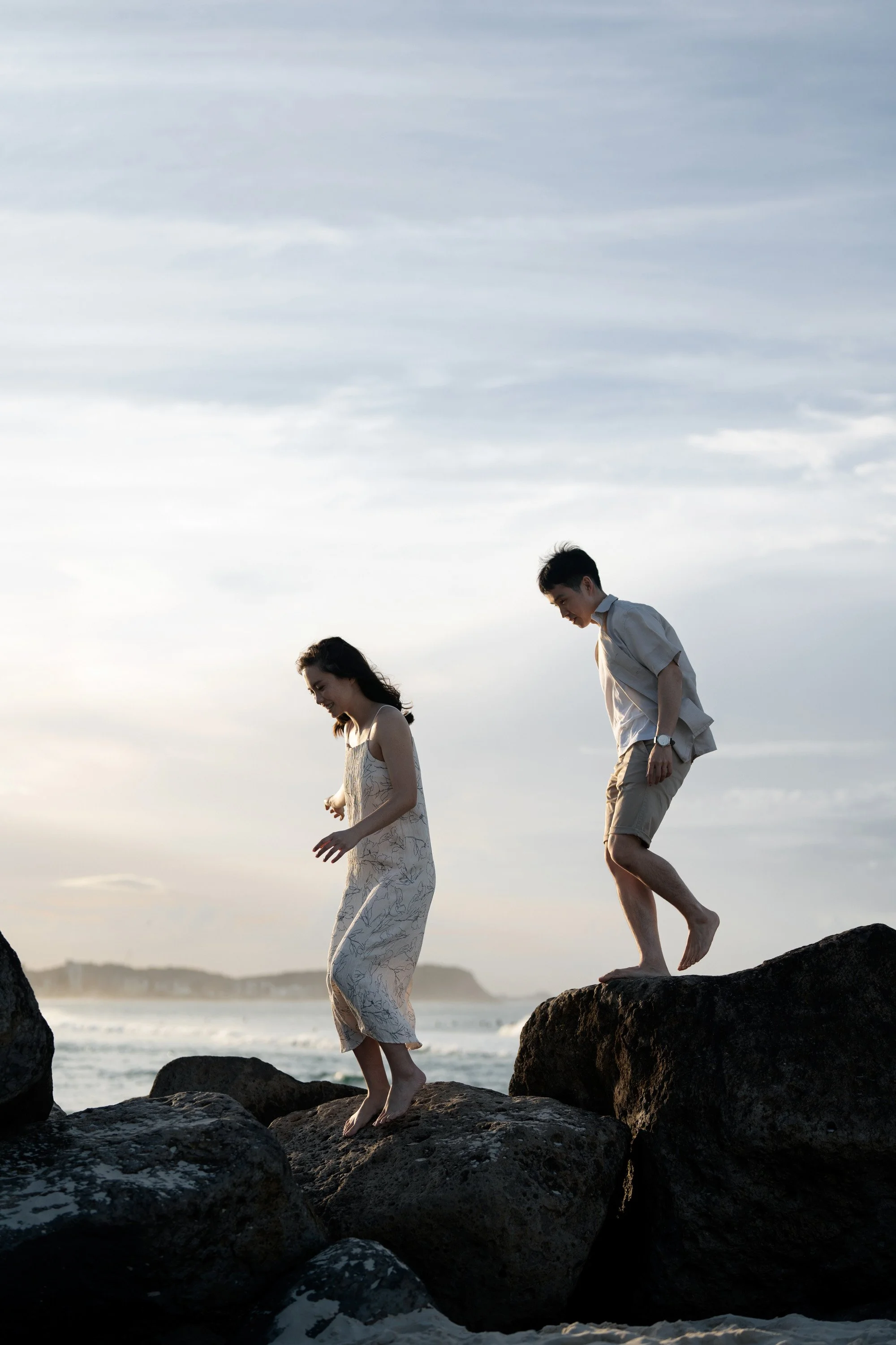 Krystel and Paul running on the rocks in Gold Coast in a engagement photo session in Currumbin Rock