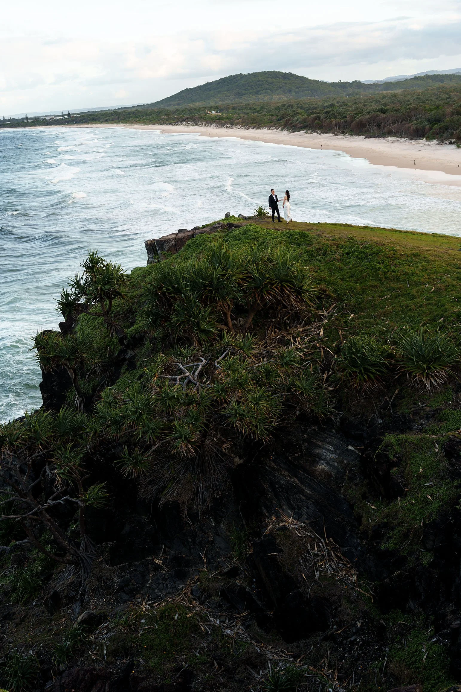 engagement experience with Margaret and Silva holding hands shoot faw away, they in the mountain top, ocean and mountain at the background