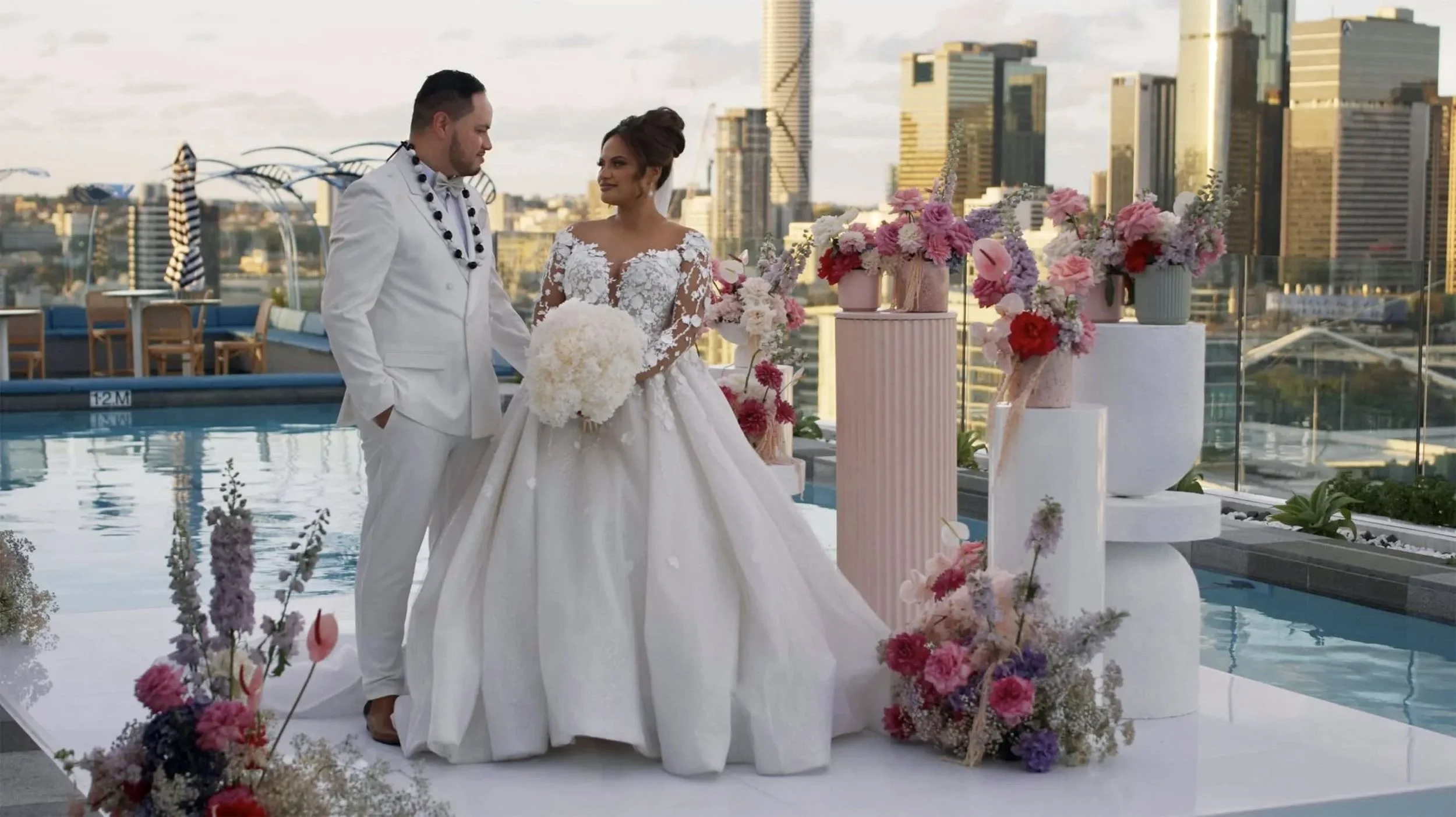 Zienne and Fagalua stand next to each other in the centre stage and flower surrading surrounding in Lina Rooftop