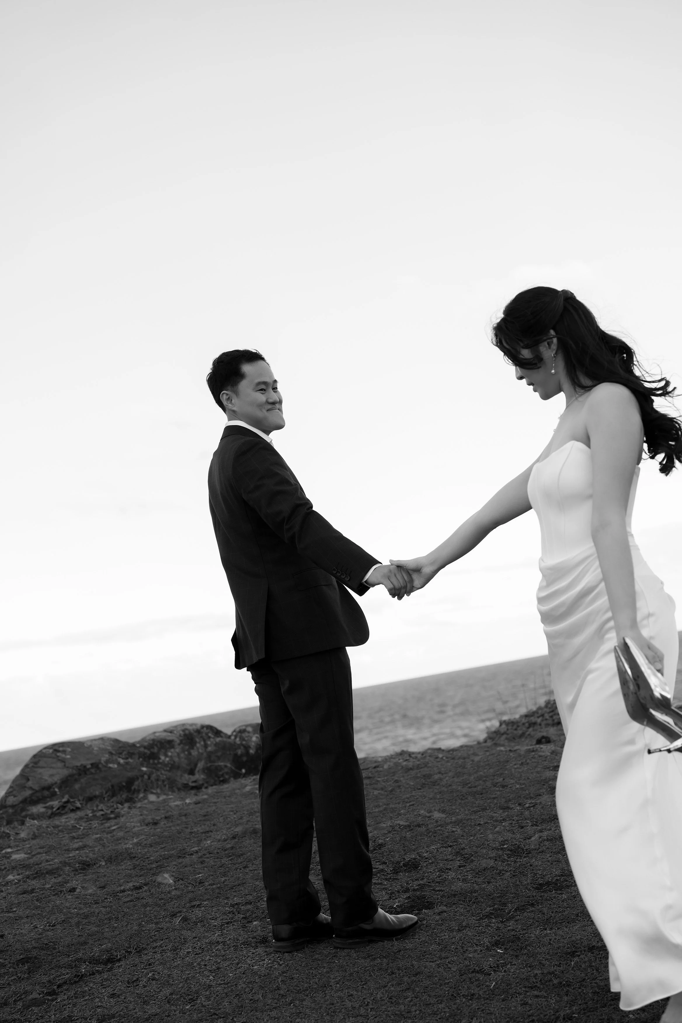 Margaret holding Silva's hand walking around him, and hthe other hand holding her shoes