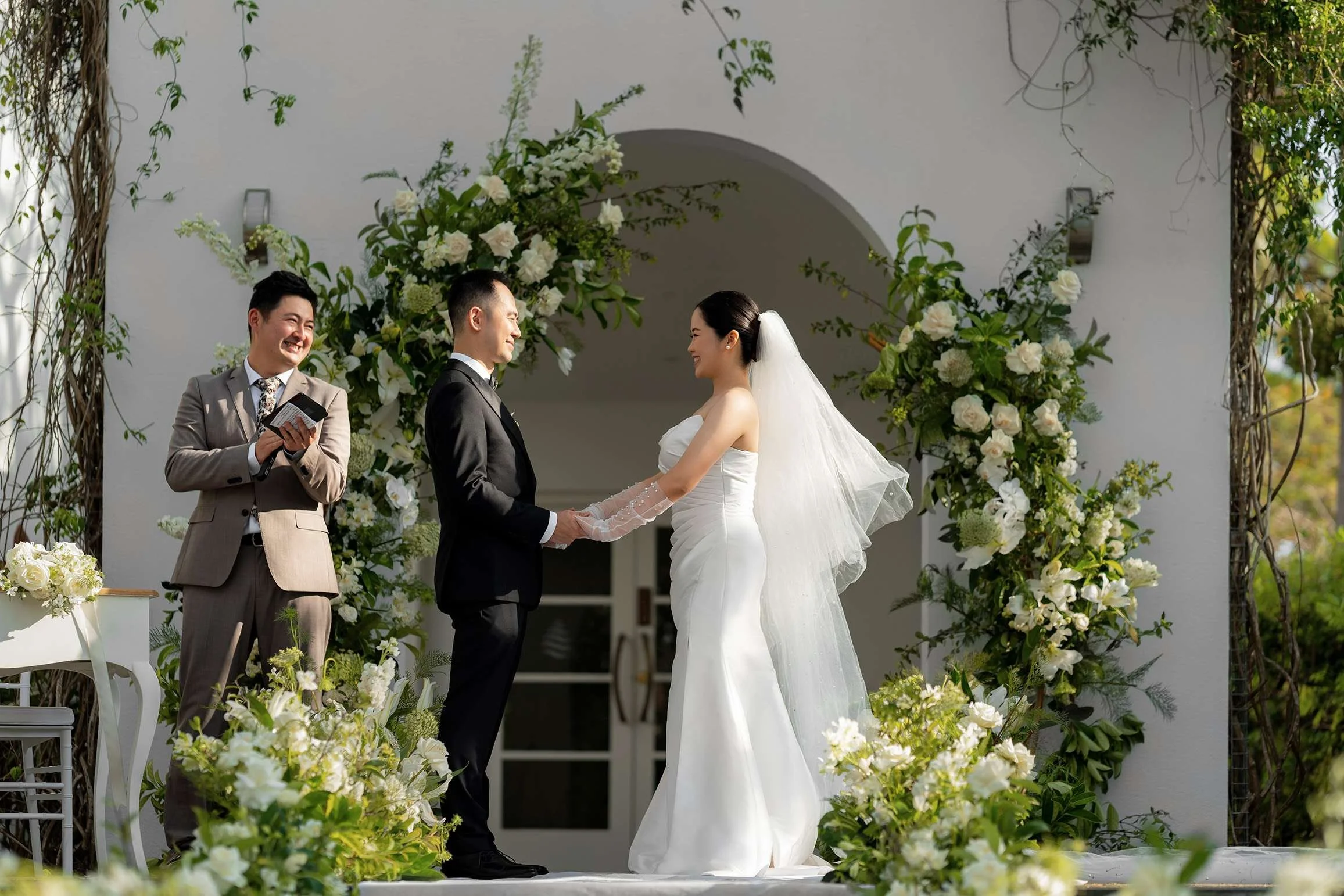 Wendy and Alex holding hands look at each other in wedding ceremony