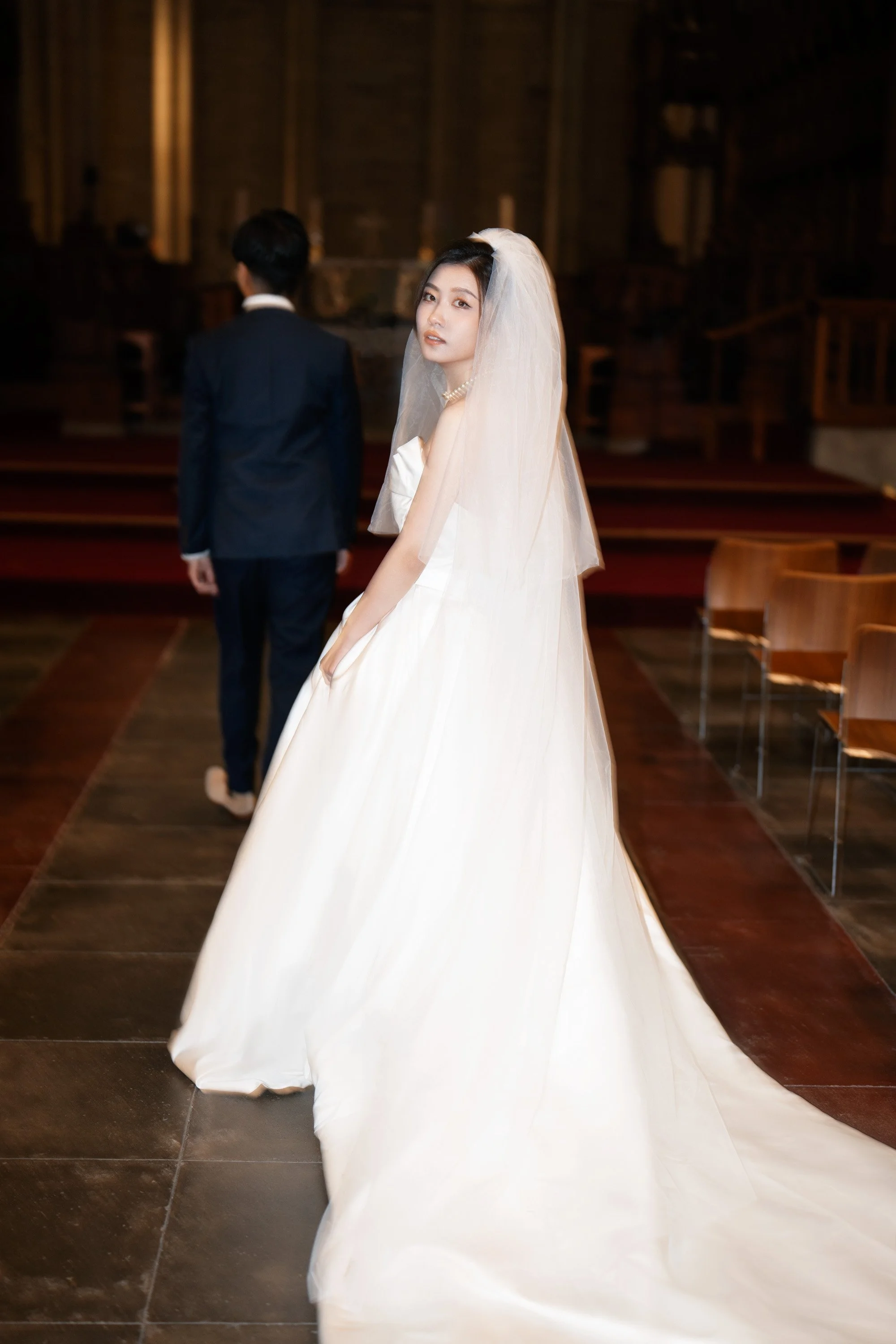 bride Cassie follow groom Leo and she look back to the Brisbane wedding photographer Whistler in St John's Cathedral in Brisbane