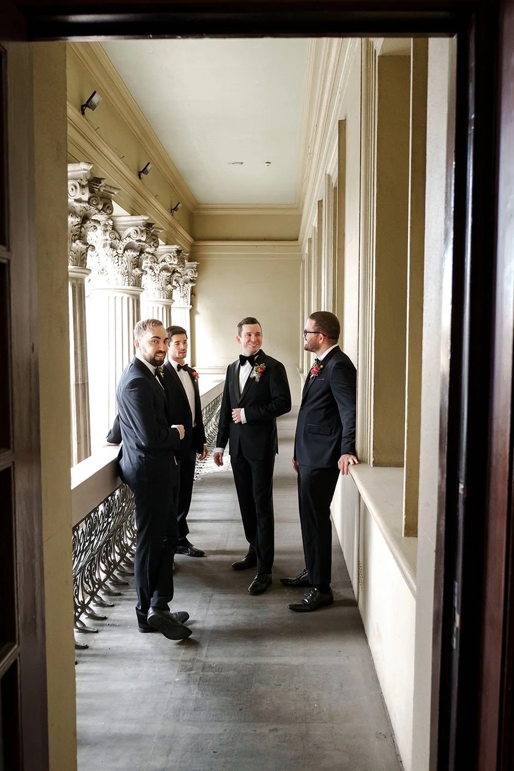 groom Cliffe's groomsmen stand around him and talk to him
