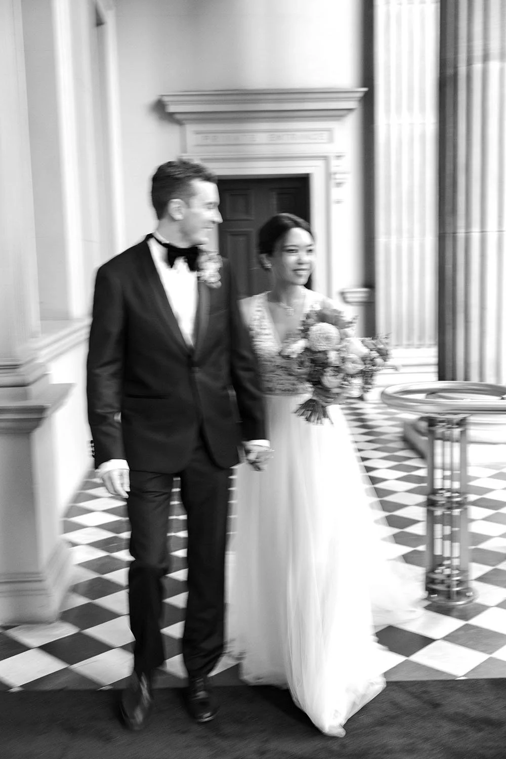 groom Cliffe holding bride Nori's hand while look at her when they walking together