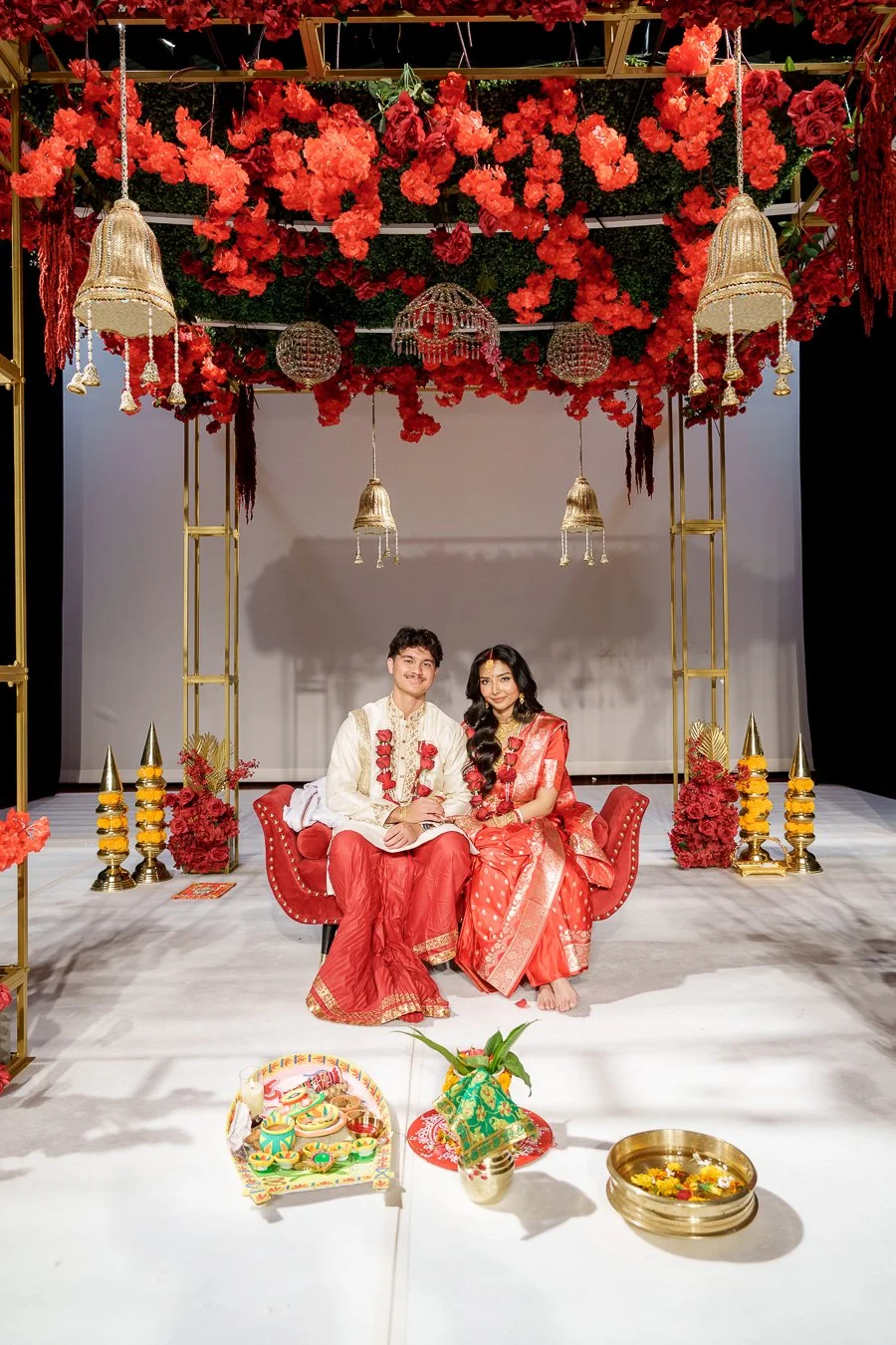 Amrita and Casey sitting next to each other look at the Brisbane wedding photographer Whistler Li in their traditional Hindi outfit
