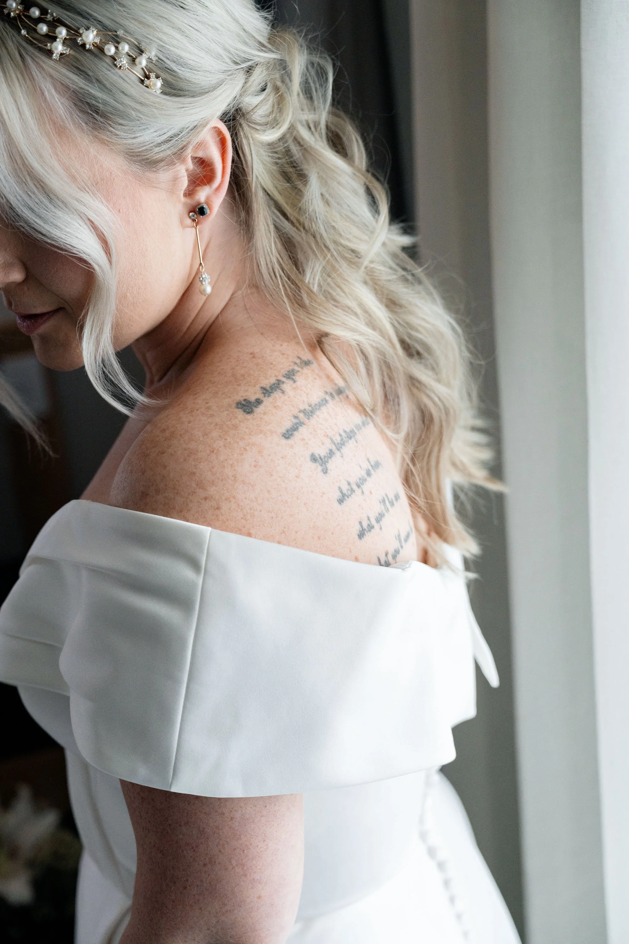 Close-up of Kyra's shoulder tattoo, telling a personal story and adding a unique, meaningful touch to her wedding day look