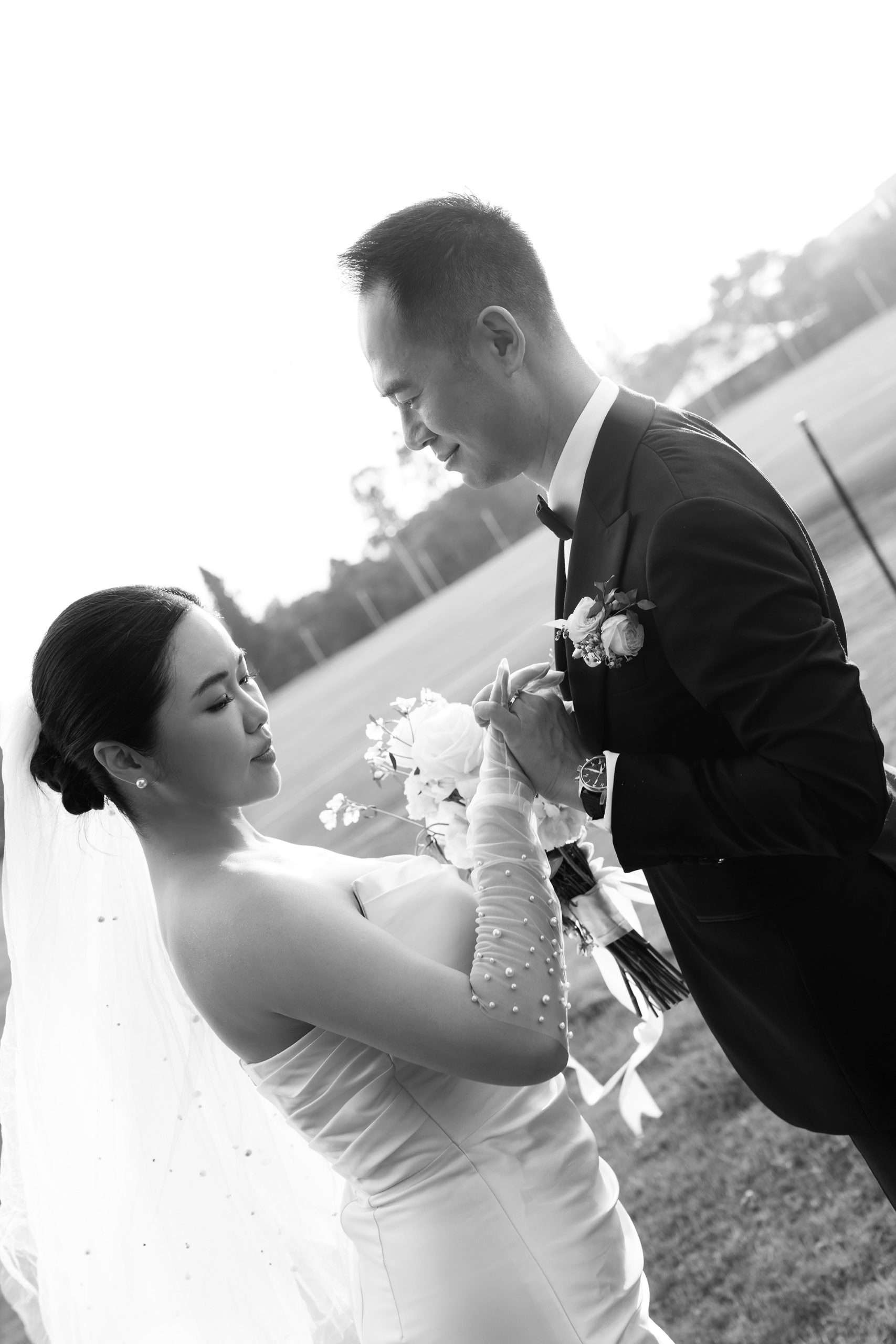 bride Wendy and Alex hand holding and look down to his chest