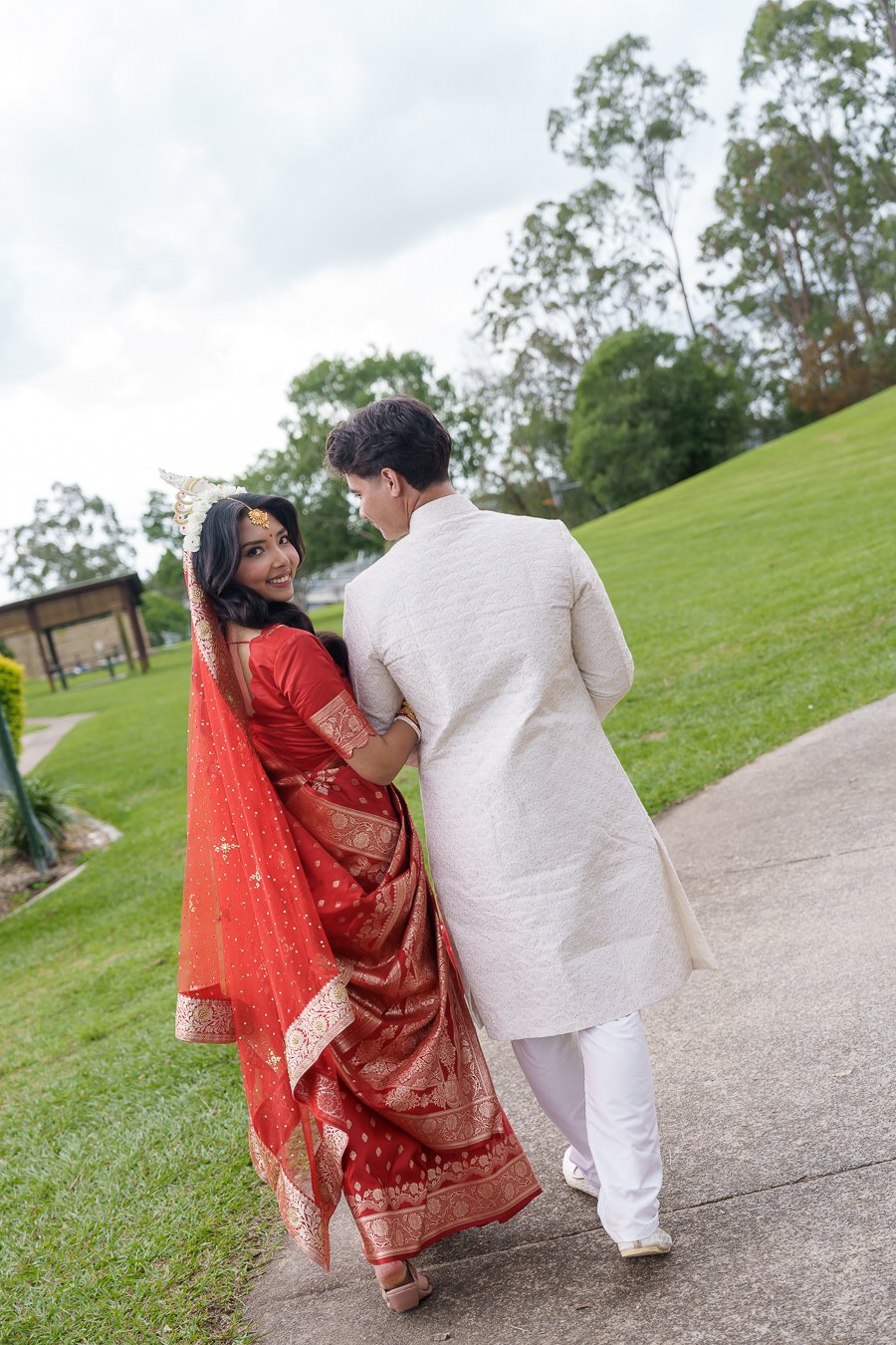 Amrita holding Casey's arm look back and they both walking ahead